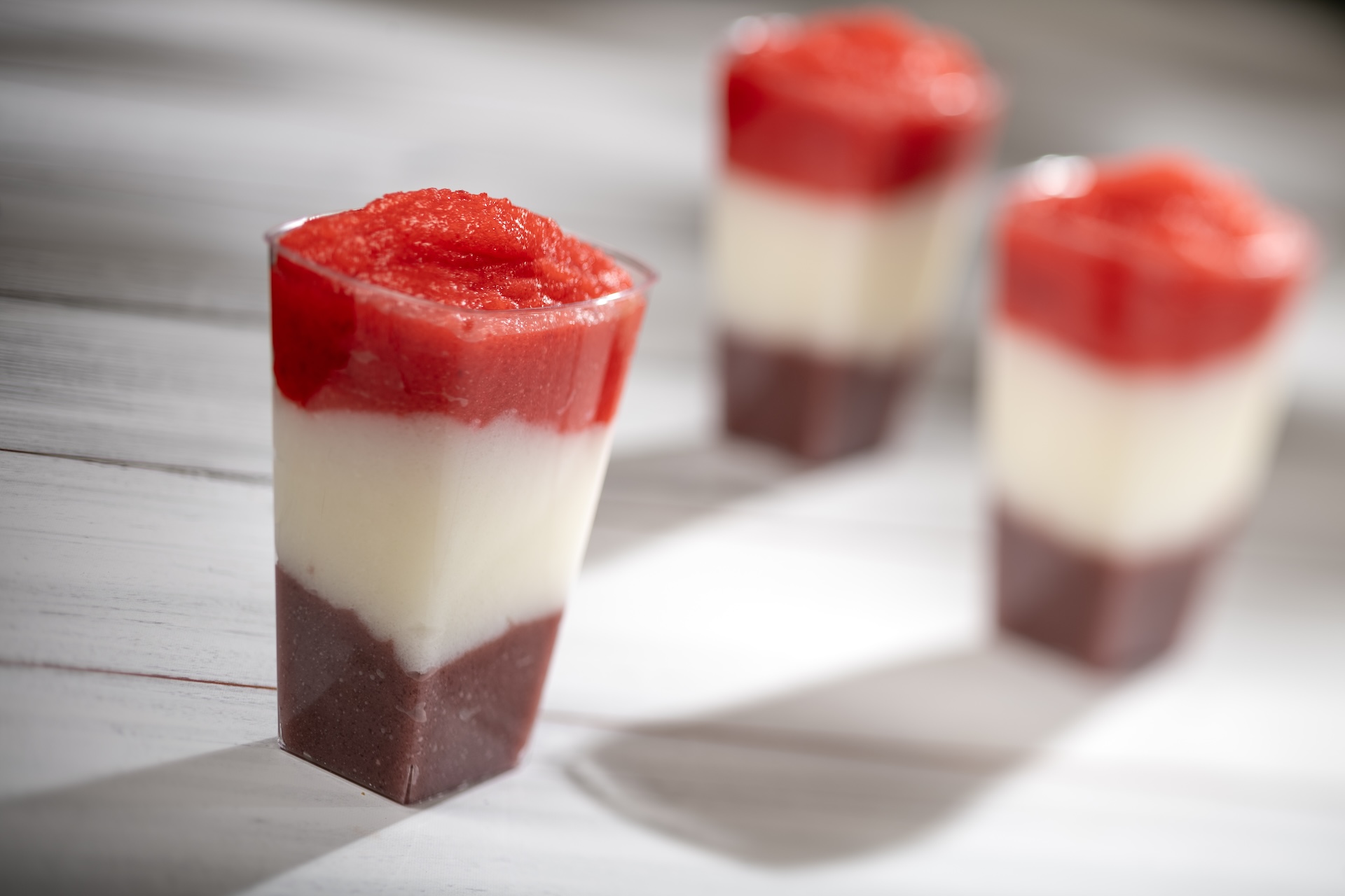 Layered Berry-Pi&ntilde;a Colada Smoothie: Wild berry, pi&ntilde;a colada, and strawberry with spiced rum