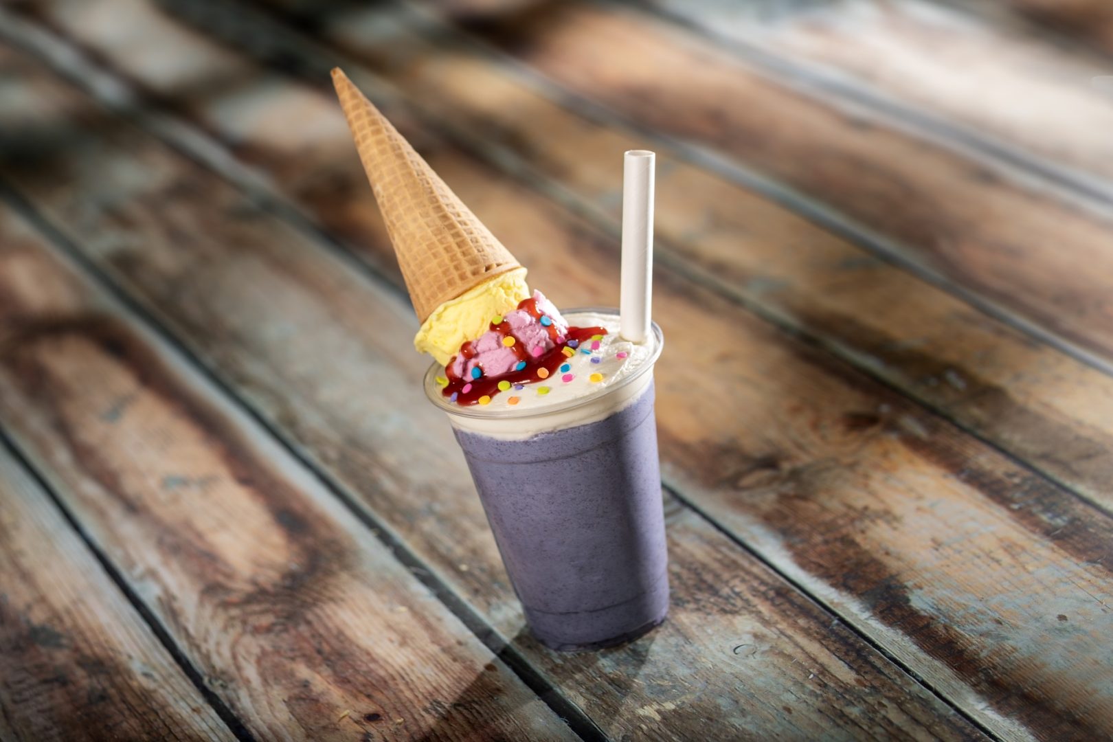 The Architecture of Drip: Blueberry-flavored gelato topped with scoops of banana and berry whipped cream, a waffle cone, and sprinkles (New)