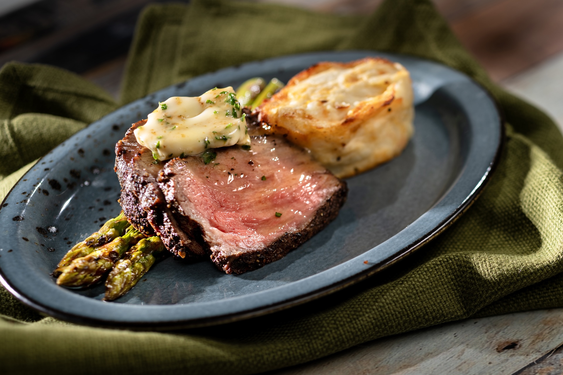 Peppercorn-crusted Striploin with grilled asparagus, potatoes au gratin, and au poivre butter (New)