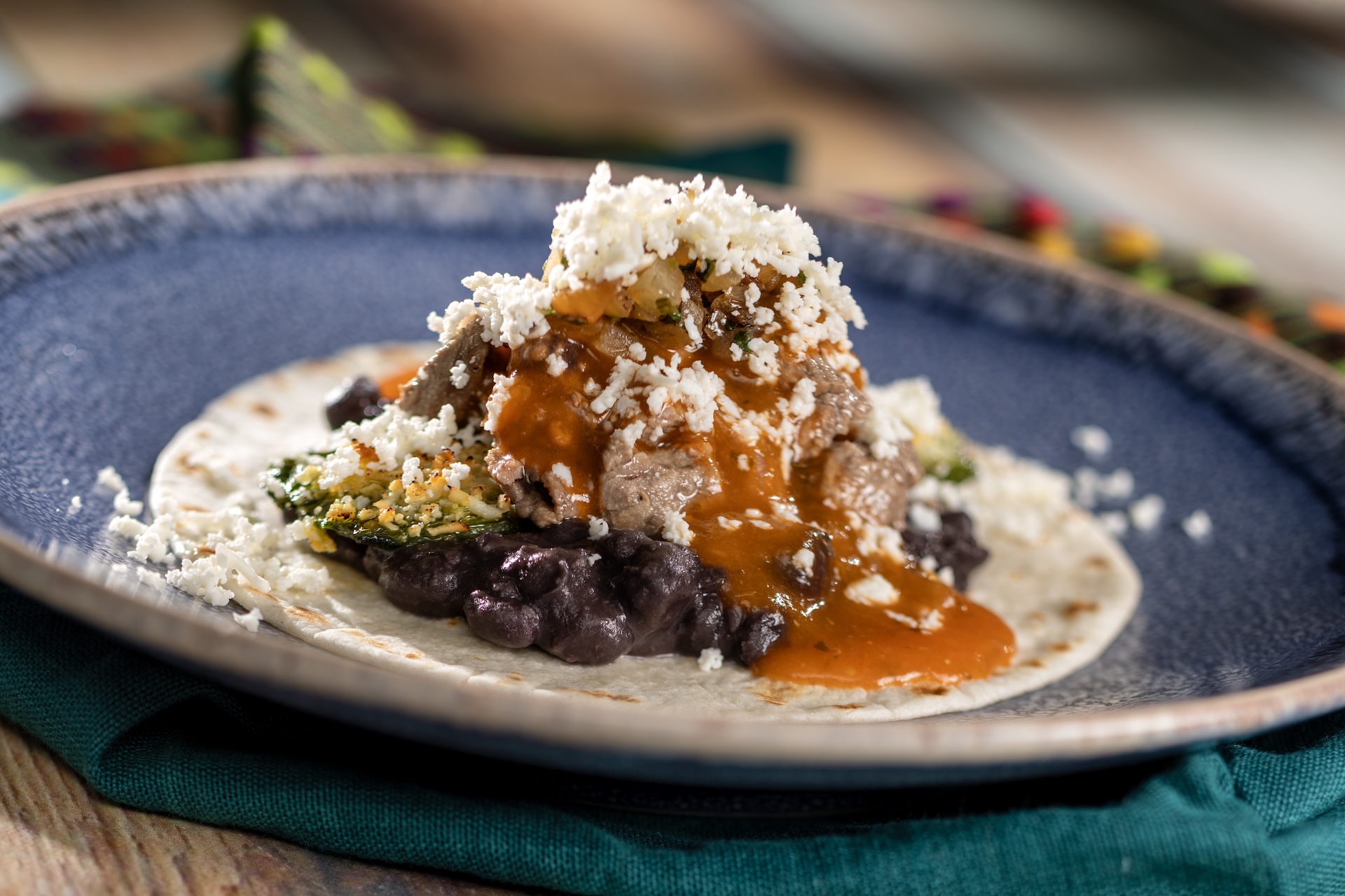 Chile Relleno Taco: Flour tortilla filled with seared beef tenderloin, poblano pepper, black beans, and salsa roja (New)