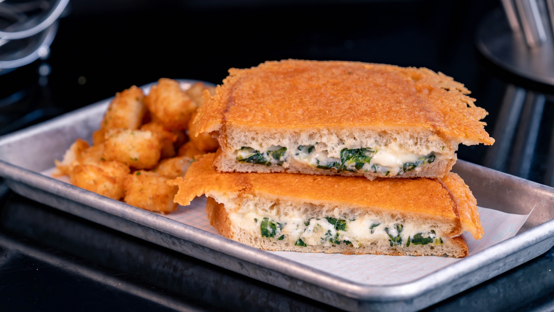 Gigabyte Grilled Cheese: Spinach and artichoke on parmesan-crusted sourdough served with potato bites (New)