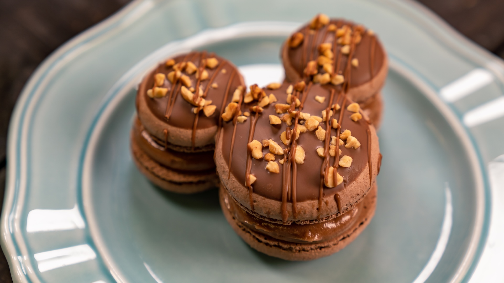 Mickey-shaped Macaron made with SNICKERS bar pieces: Chocolate Mickey-shaped macaron filled with caramel ganache, made with SNICKERS bar pieces