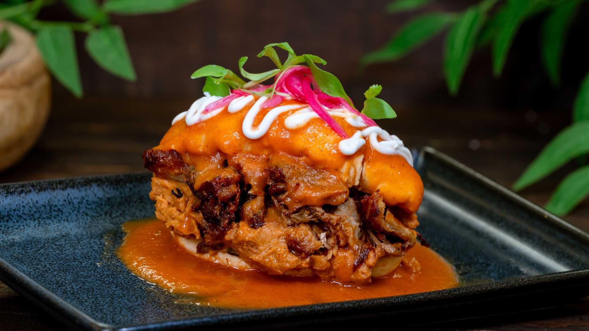 Torta Ahogada: Braised pork carnitas, frijoles charros, pickled onion, and salsa (New)