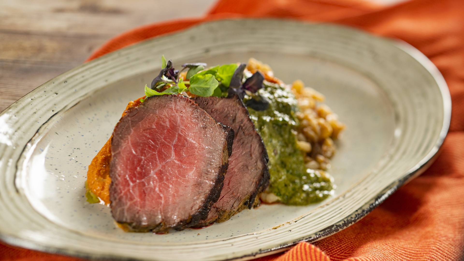 Grilled Beef Strip Loin with tomato risotto, tomato beurre blanc, and basil pesto