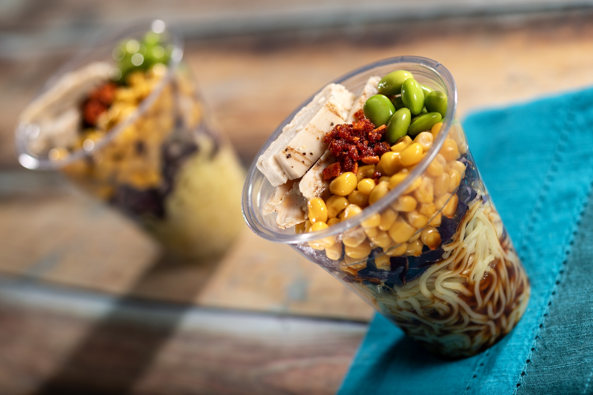 Ramen Cup: Cold ramen noodle salad in a cup with fresh vegetables and grilled chicken served with yuzu-soy vinaigrette and chili oil