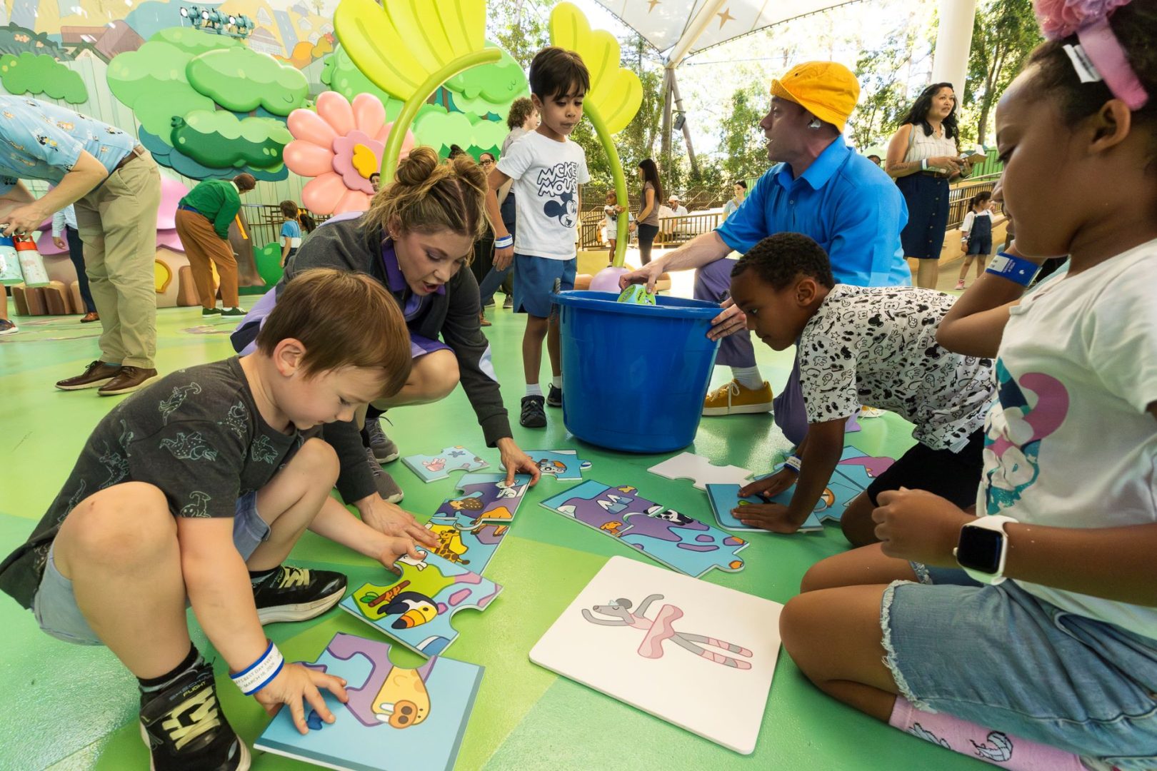 Children and adults engaged in a colorful puzzle activity at Disneyland.