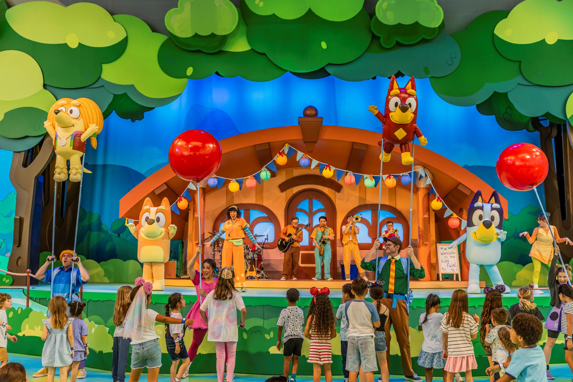 Children enjoy a live performance with Bluey characters at Disneyland.
