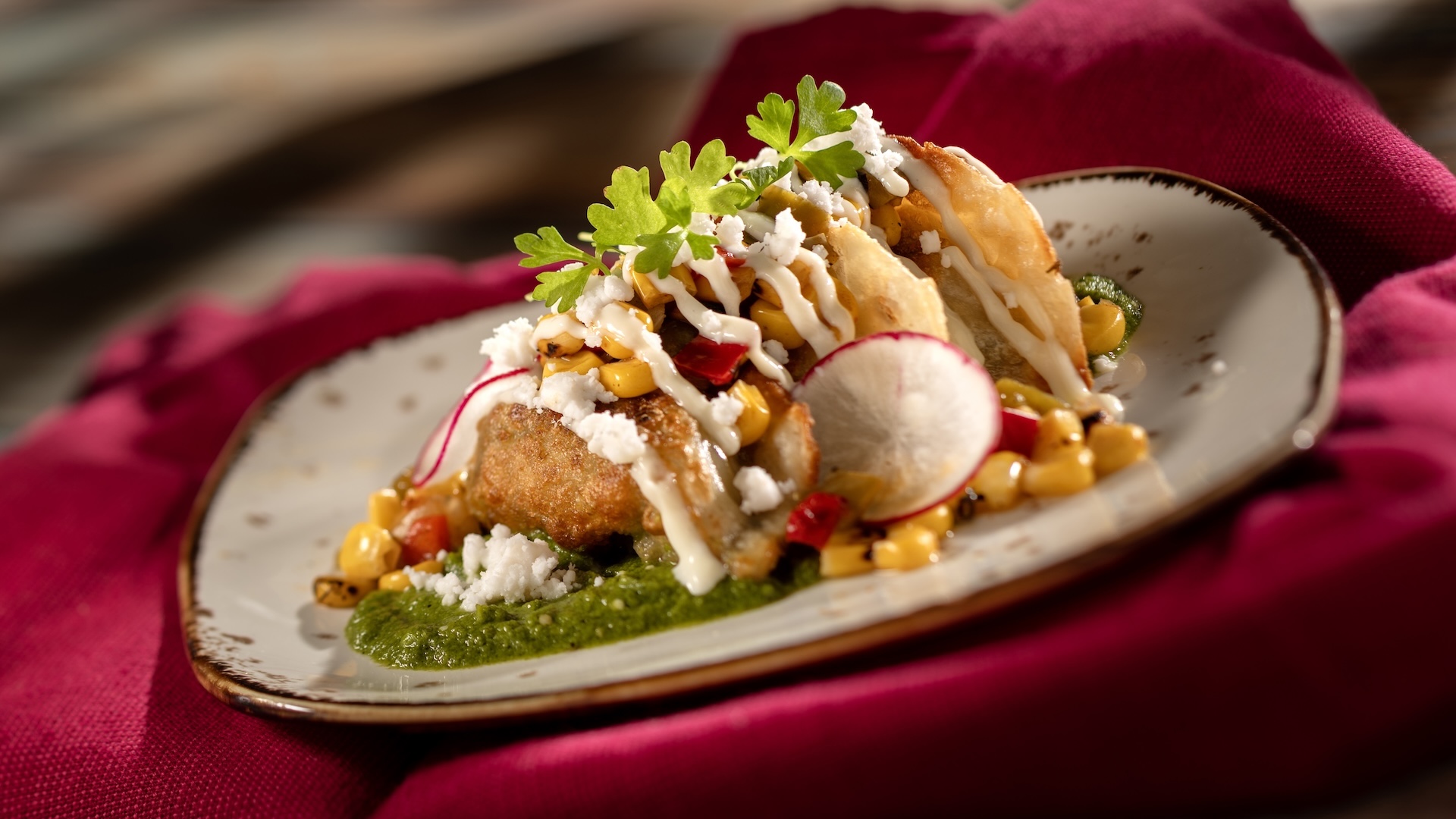 Street Corn-style Dumplings: Chicken Dumplings with Tomatillo Salsa Verde, Street Corn Salad, Cotija, Lime Crema, and Cilantro (Gyozas of the Galaxy)