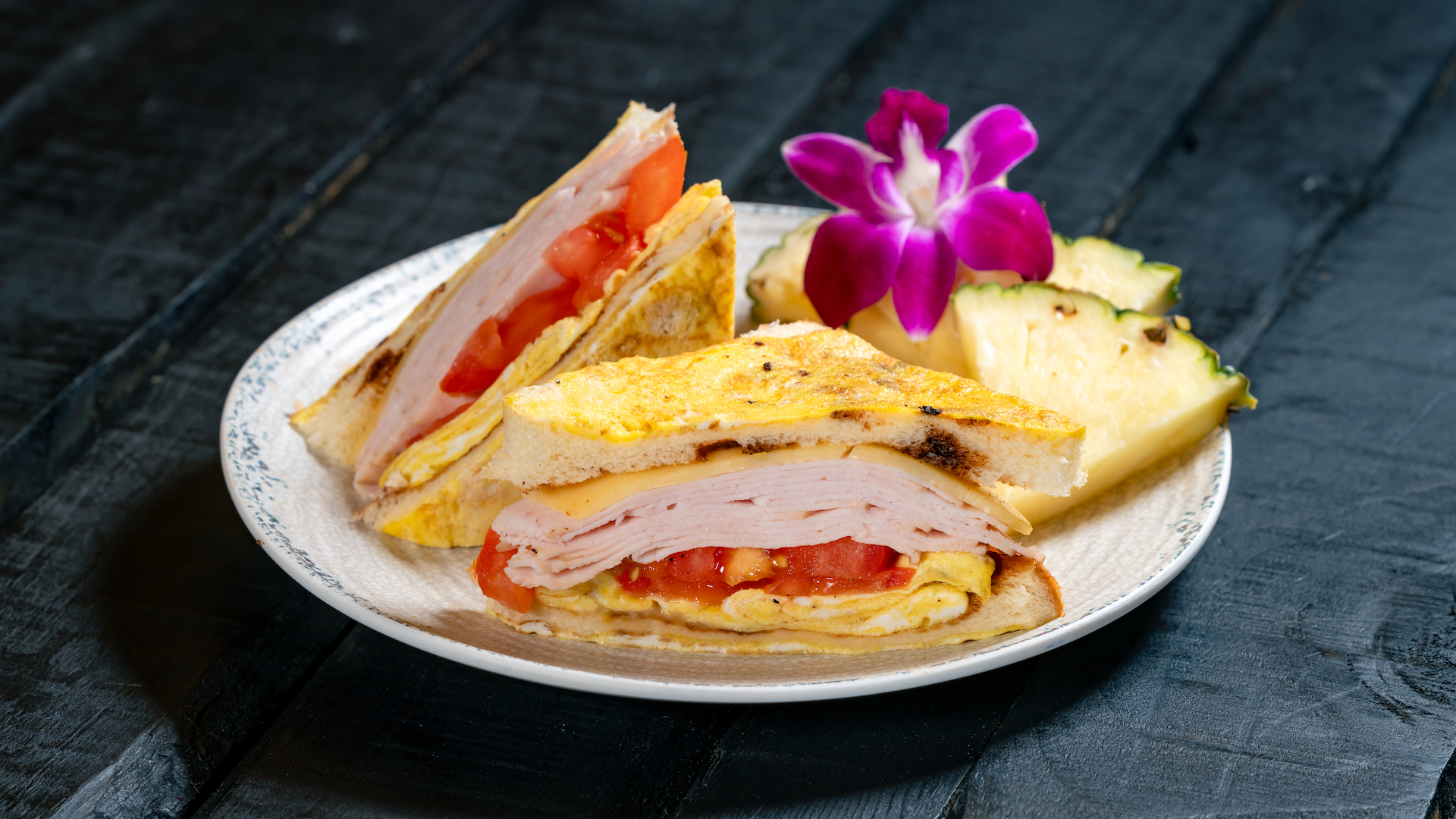 Trader Sam's Enchanted Tiki Bar Disneyland Hotel Korean-style Egg Sandwich: Scrambled Egg, Roasted Turkey, Fresh Tomato and Havarti on Japanese Milk Bread, served with Pineapple Wedge