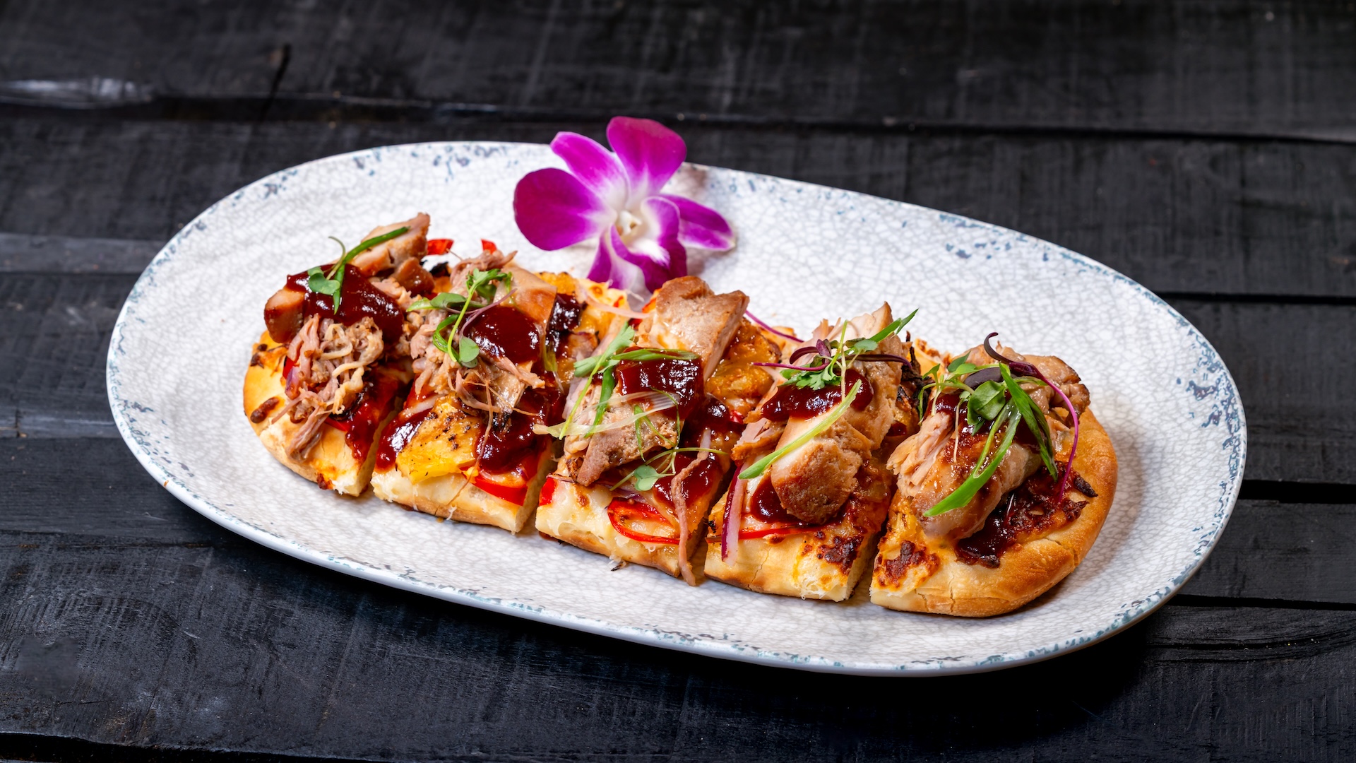 Trader Sam's Enchanted Tiki Bar Disneyland Hotel BBQ Chicken Flatbread: Teriyaki chicken, red onions, mozzarella cheese, micro herbs, Fresno chilies, green onions, and pineapple (option to add Kālua pork)