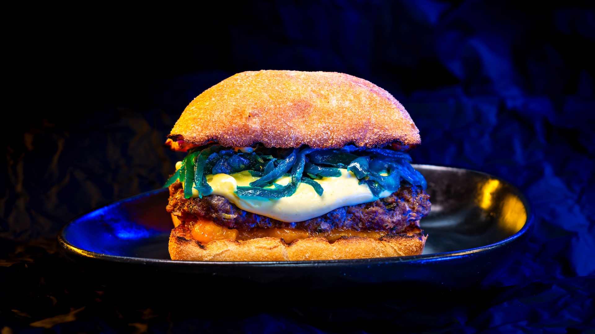 Bounty Bun with Spiced Beef and Pork with tomato chutney, golden aioli, and saut&eacute;ed blue onions (New)