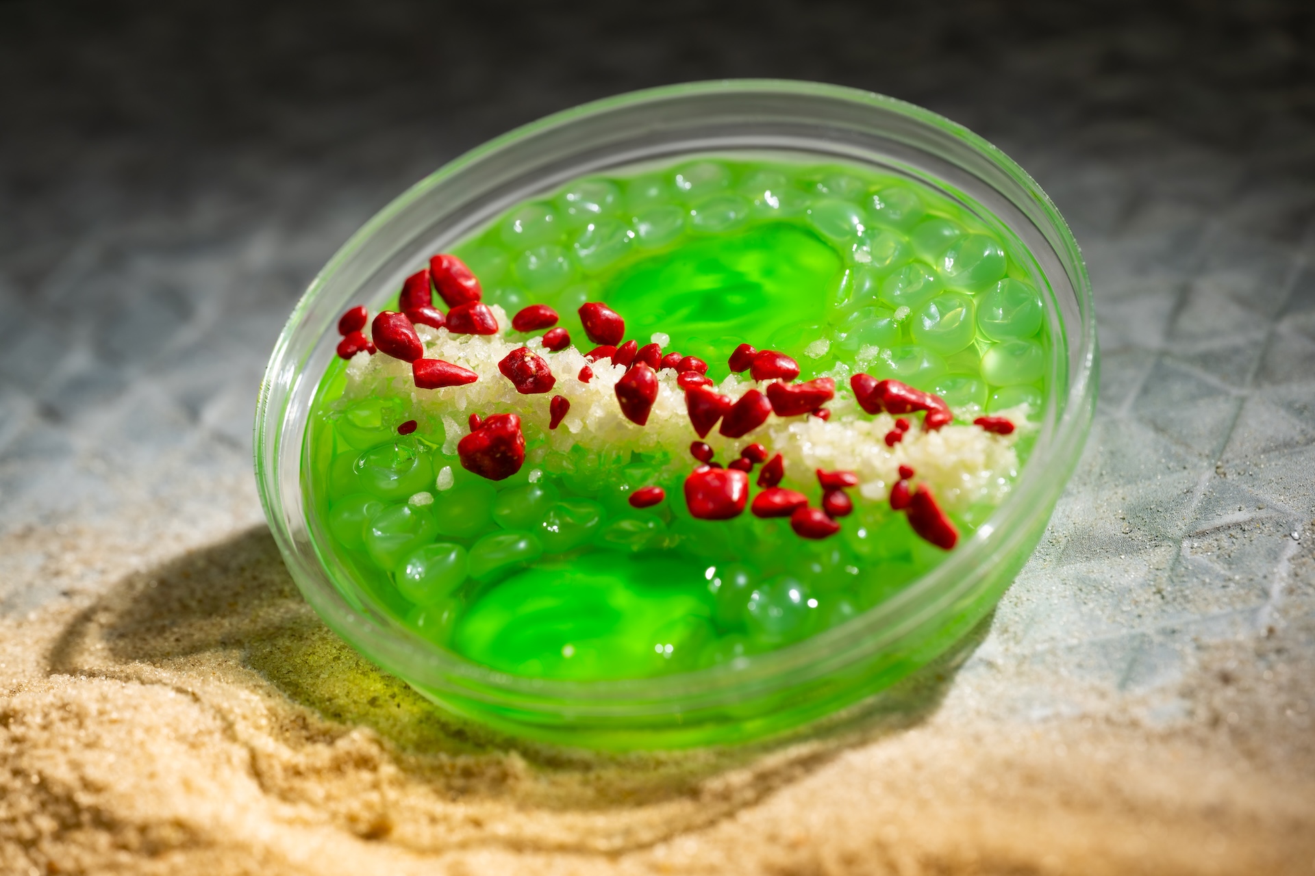 Rodian Ration: Tito's Handmade Vodka, DeKuyper Pucker Sour Apple Schnapps Liqueur, green apple, and Sprite with fruit juice-filled pearls and gummy candy frogs