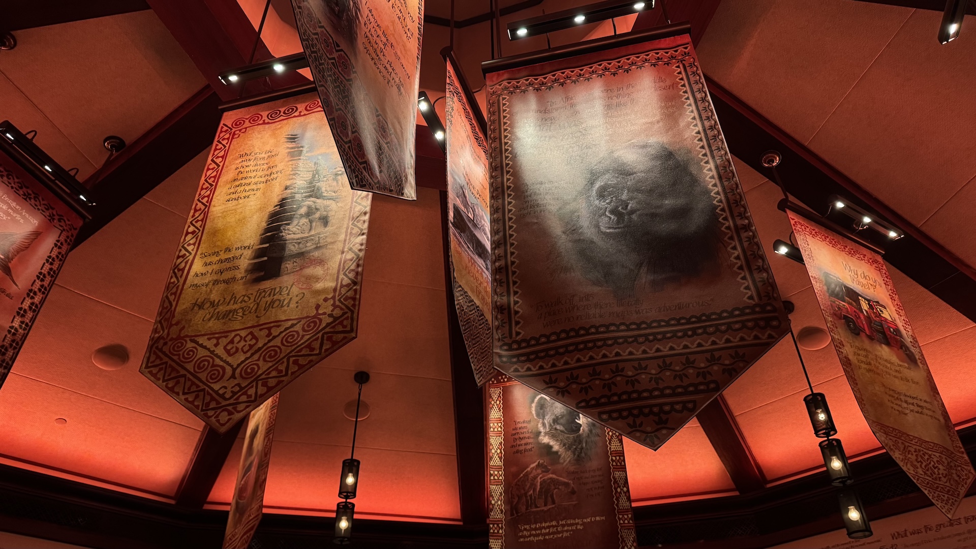 Hanging banners with artistic designs and text in a warmly lit restaurant.