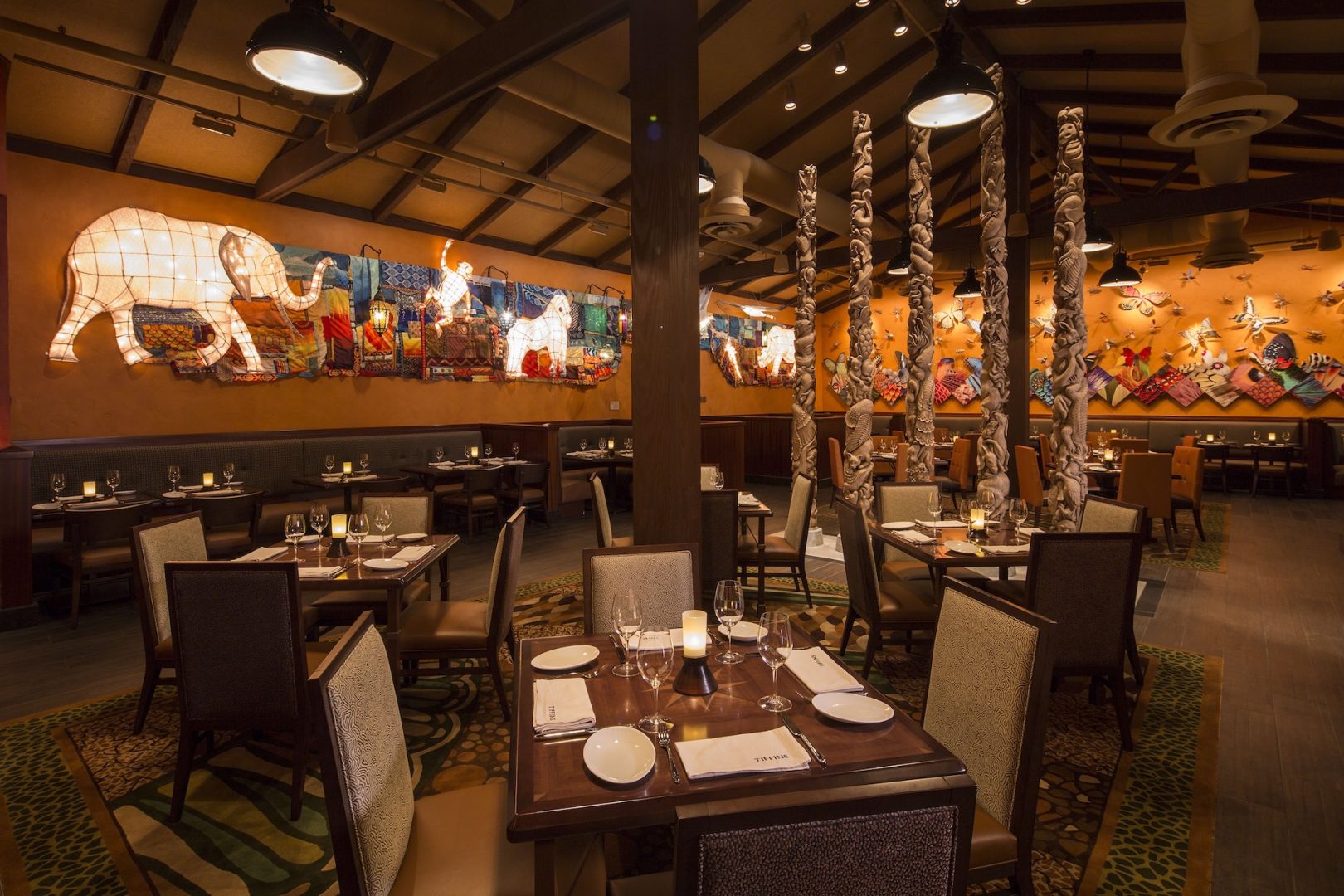 Elegant dining area with artistic decor and wooden sculptures.