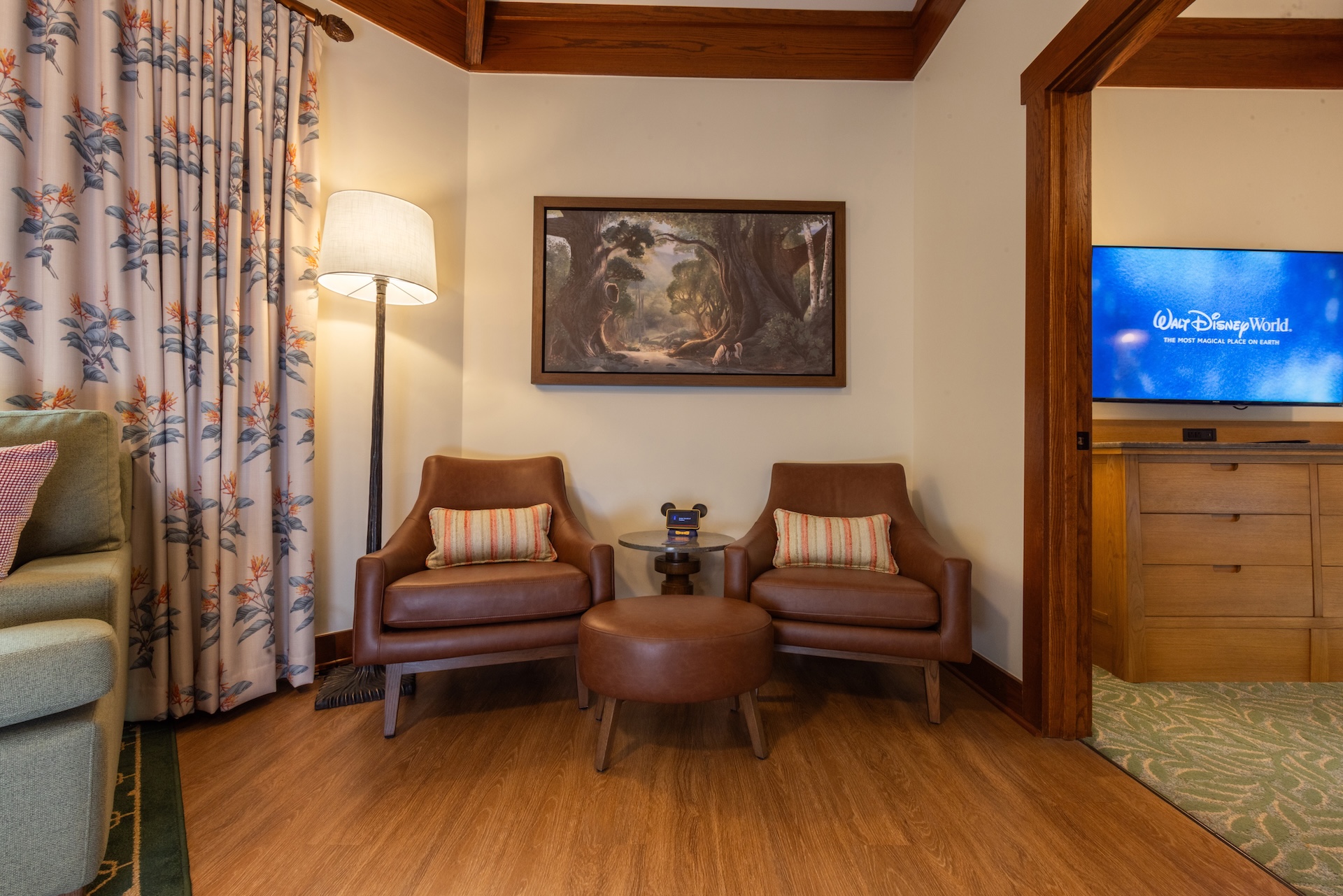 Cozy living area with two brown chairs, lamp, and wall art.