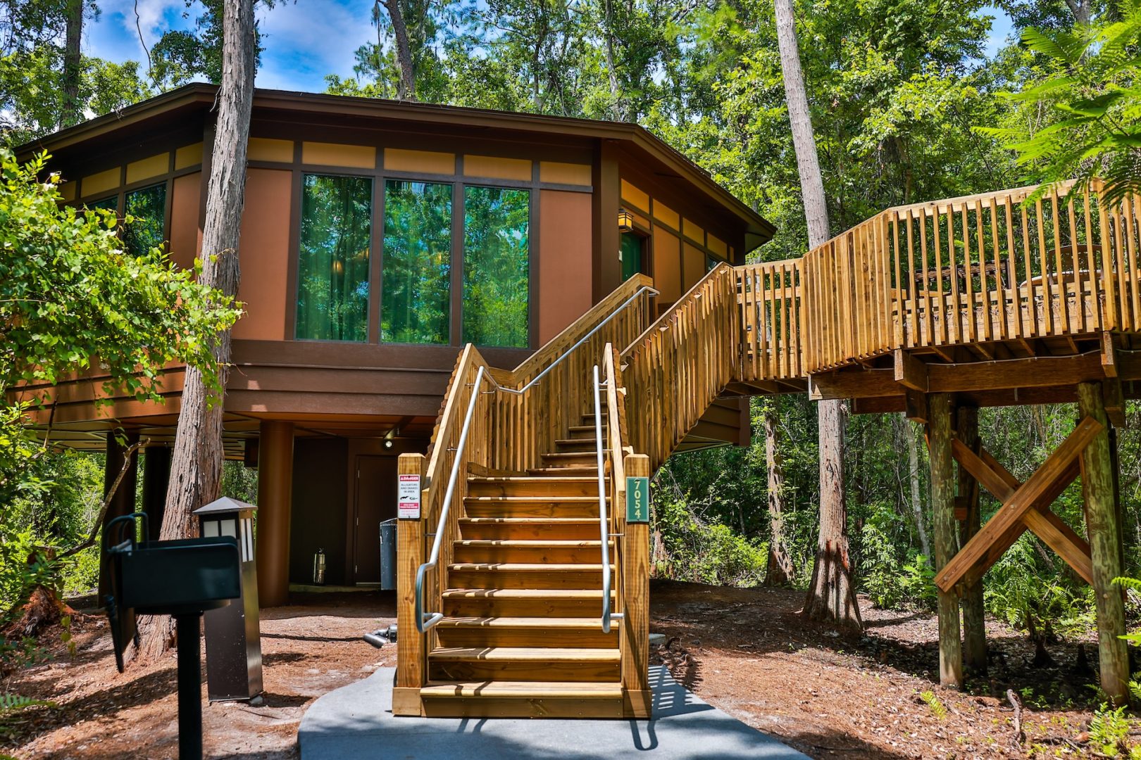 Reimagined treehouse villa with wooden stairs and surrounded by lush greenery.