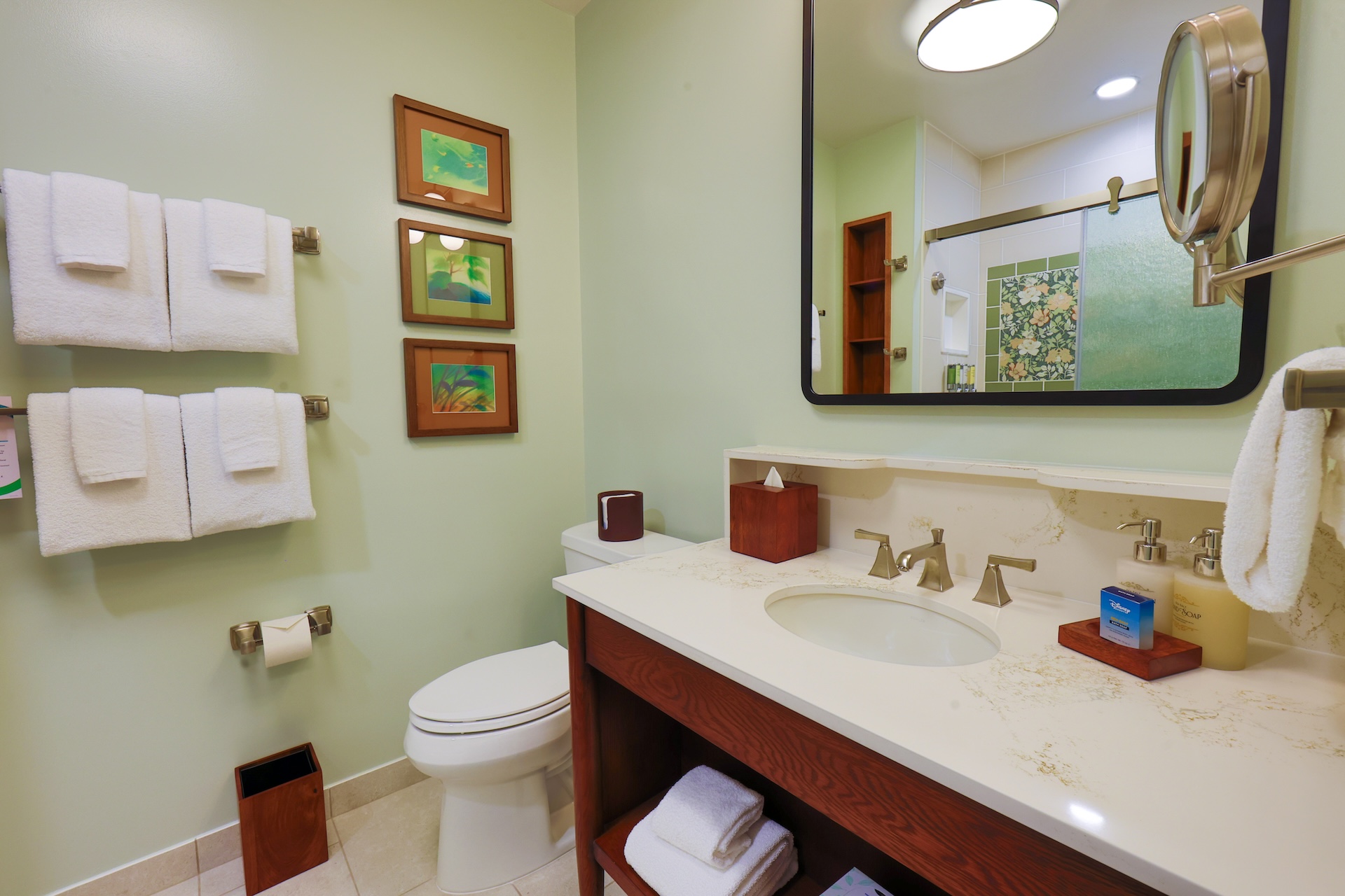 Bright bathroom featuring a sink, towels, and decorative wall art.