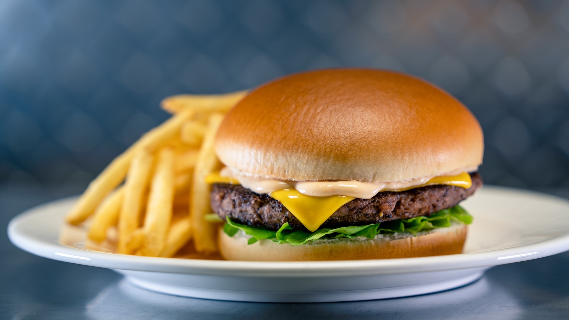 Disney Parks America 250 Foodie Guide Cheeseburger Constellation: Beef patty with American cheese, lettuce, and house burger sauce served with choice of Cuties Mandarin Orange or fries