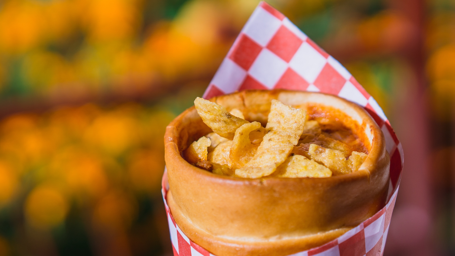 Disney Parks America 250 Foodie Guide Chili Cone Queso: Beef chili, cheddar cheese, and corn chips served in a bread cone