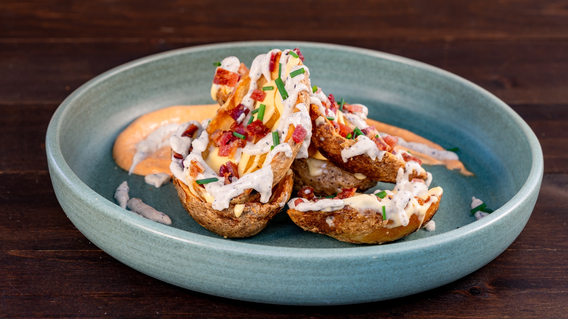 Disney Parks America 250 Foodie Guide Potato Skins with paprika a&iuml;oli, house ranch, cheddar, bacon, cheese sauce, and chives