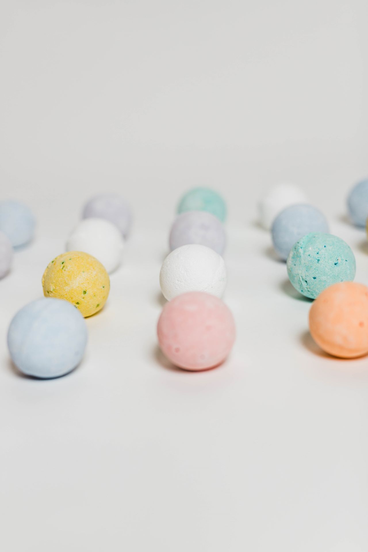 Colorful bath bombs arranged on a white background.