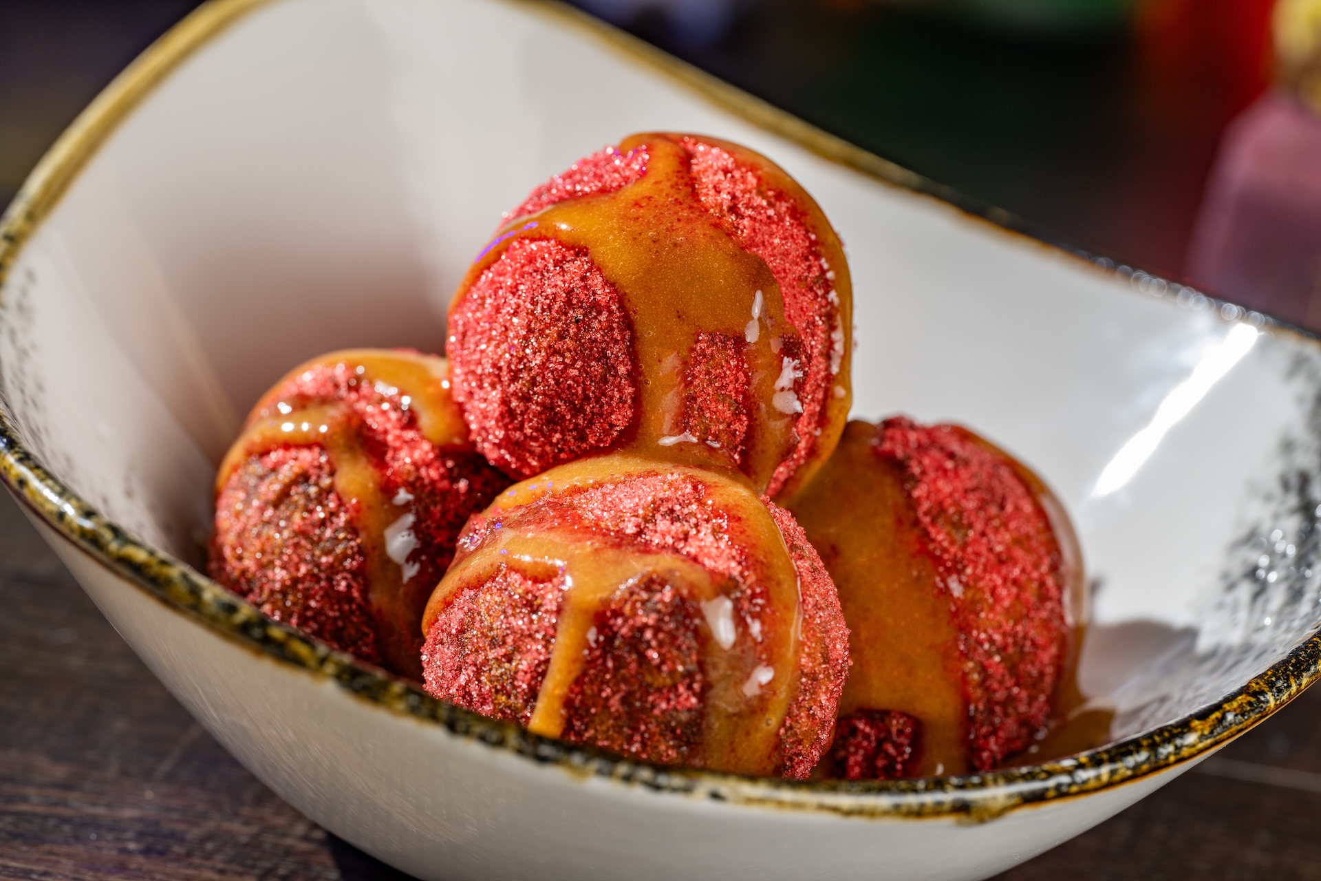 Not-So-Poison Apple Doughnuts rolled in apple cider sugar and drizzled with caramel sauce (Available during Mickey&rsquo;s Not-So-Scary Halloween Party only)