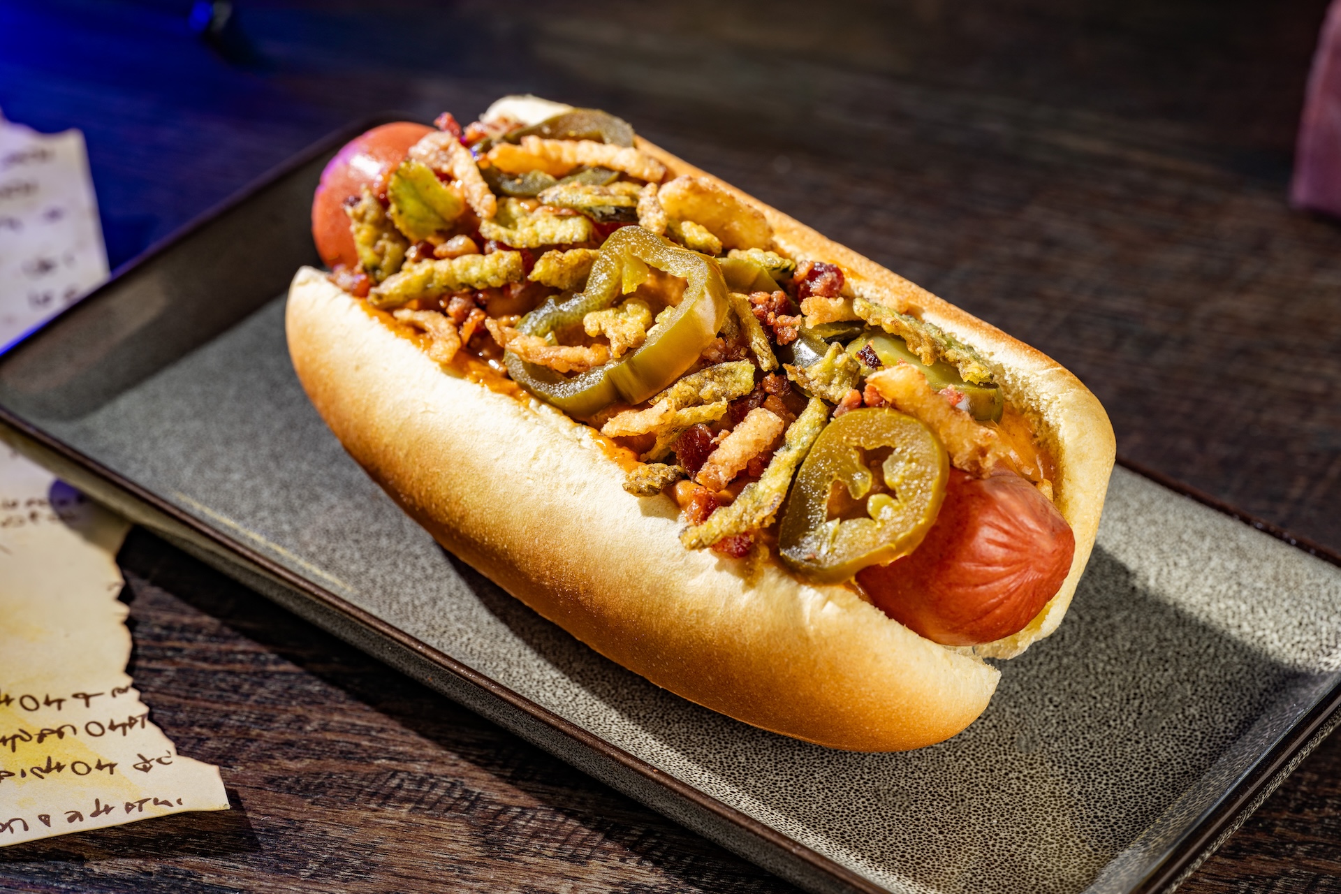Jalape&ntilde;o Popper Hot Dog topped with queso fundido, pickled and fried jalape&ntilde;os, bacon, and onions (Available during Mickey&rsquo;s Not-So-Scary Halloween Party only)