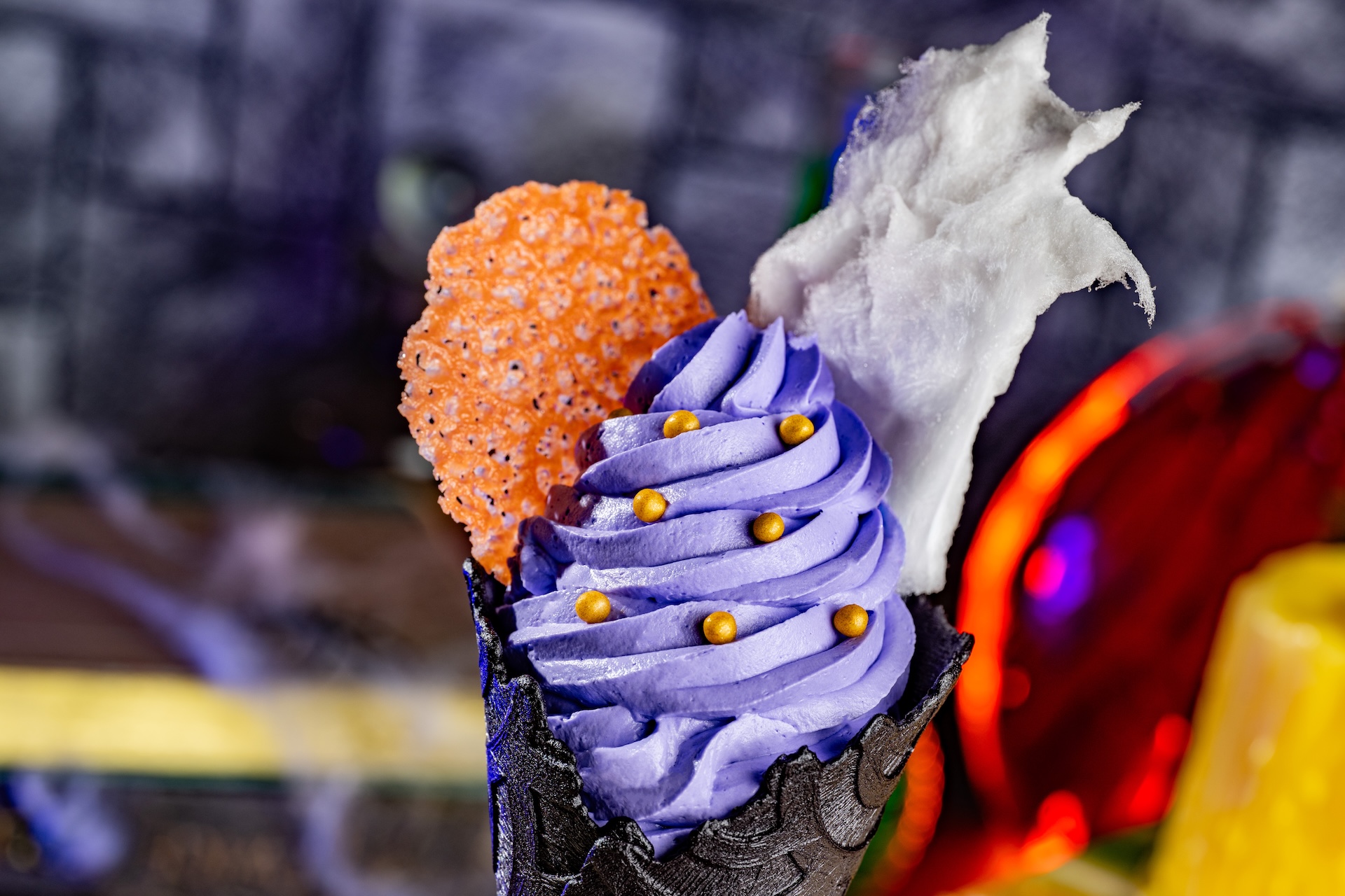 Ursula Cone: Wild berry soft-serve with candy coral and citrus cotton candy in a black vanilla cone (Available during Mickey&rsquo;s Not-So-Scary Halloween Party only)