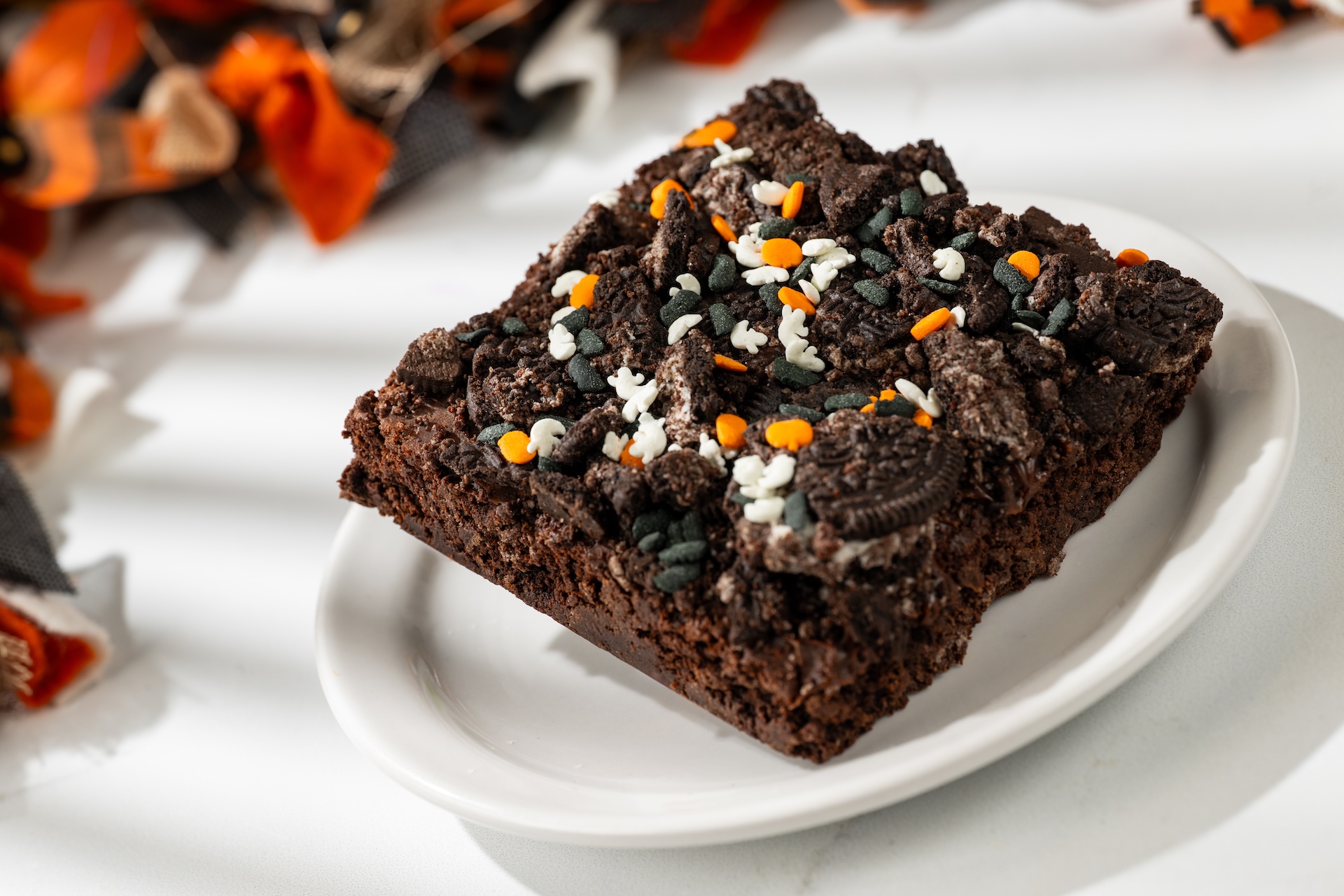 Halloween Brownie topped with cookie pieces, passion fruit crispy pearls, and chocolate coin