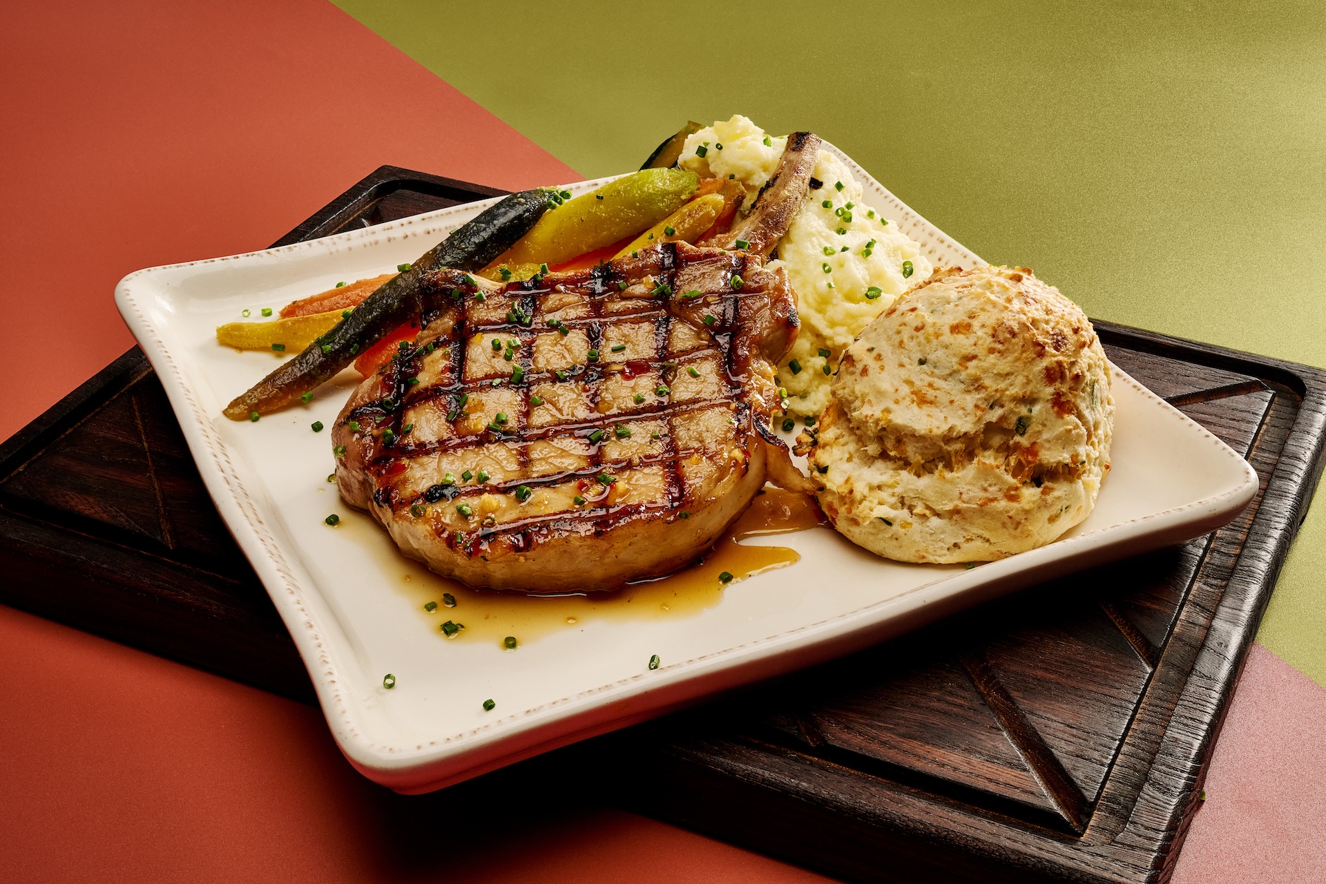 Tuscan Pork Chop: Lemon and herb-marinated pork chop served over a white bean rago&ucirc;t and white wine tomato broth with spinach, feta cheese, and tomatoes served with feta mashed potatoes