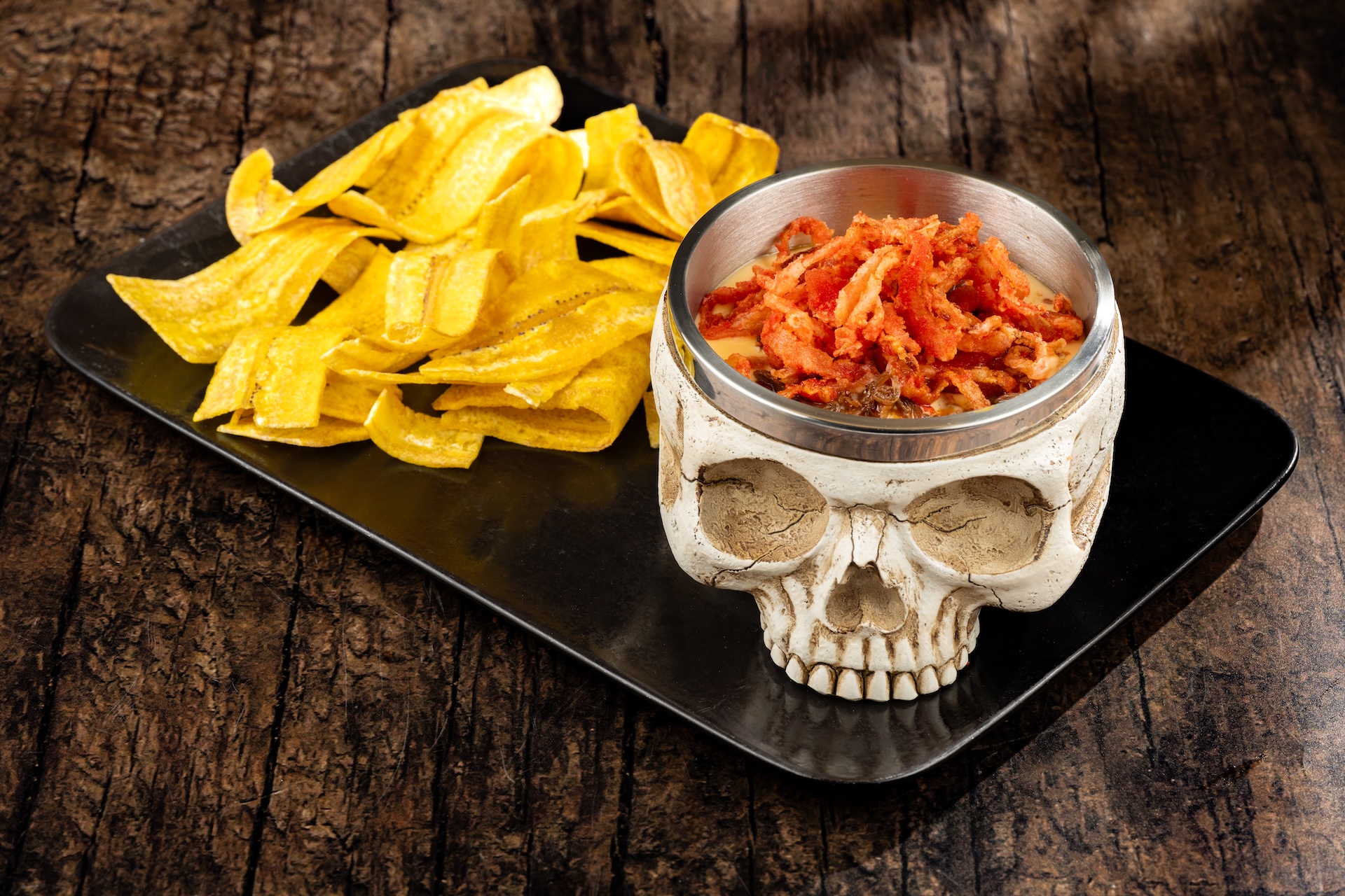 Skull of the Dead Dip: Barbacoa beef, cheddar sauce, spicy fried onion straws, and plantain chips (New)