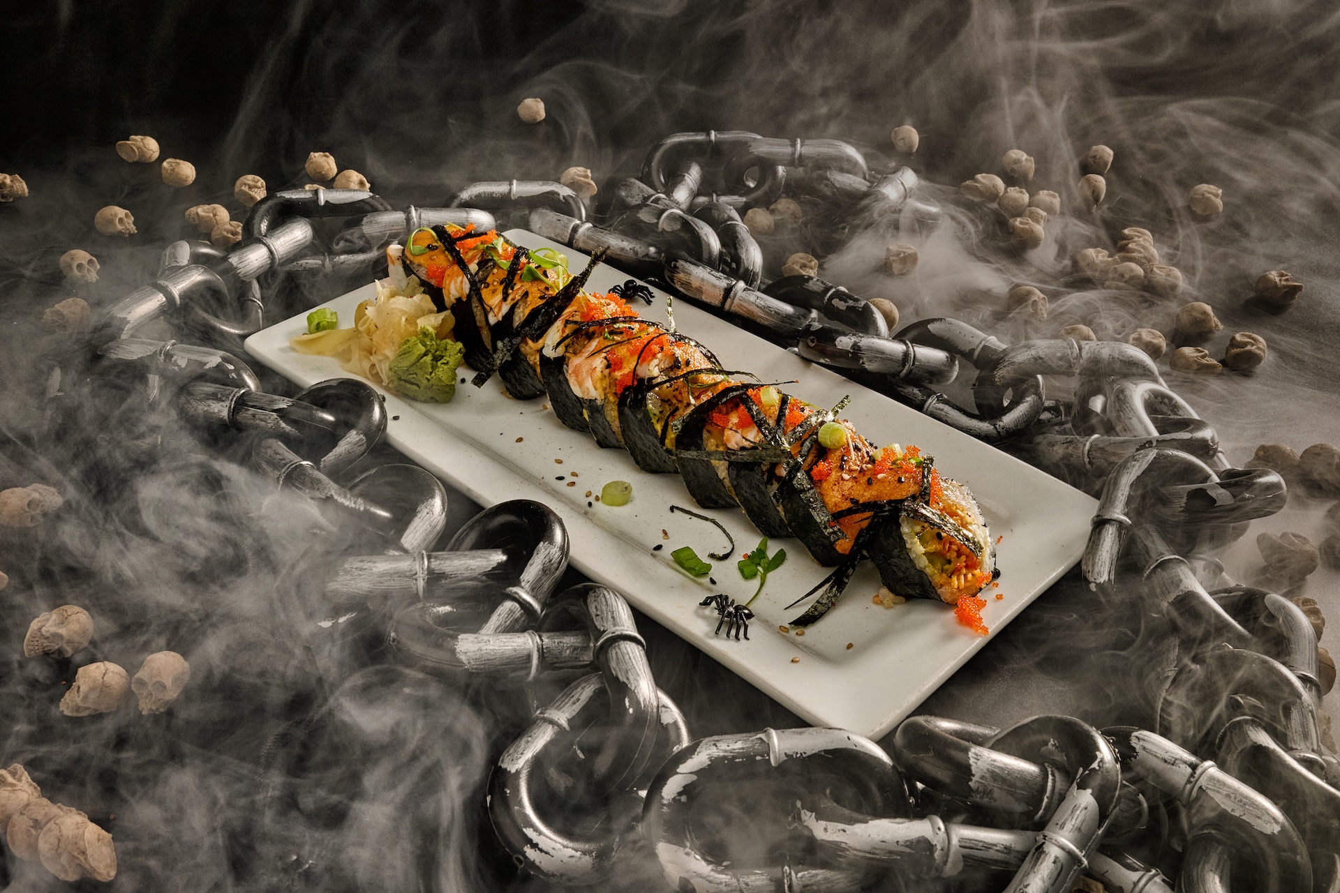 All Hallow&rsquo;s Eve Sushi Roll: Sushi rice, cream cheese, cucumber, avocado, shrimp, spicy volcano mix topped off with torched nori paper yum yum sauce, eel sauce, masago, and scallions.