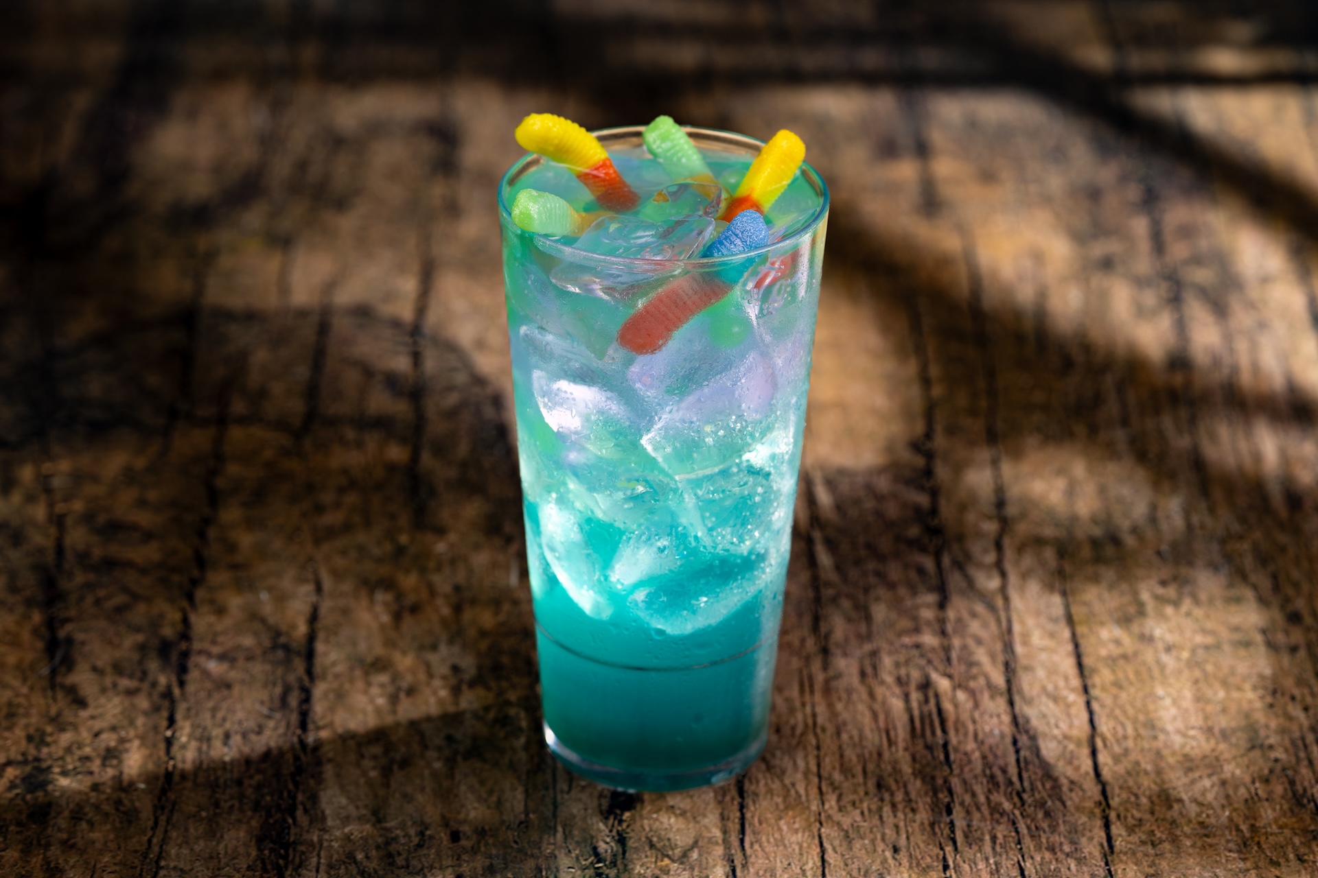 Viper&rsquo;s Nest: DOLE Pineapple Juice, white cranberry juice, green apple syrup, blue cura&ccedil;ao syrup, Sprite, and butterfly pea extract topped with green apple juice-filled pearls and gummy candy (New)