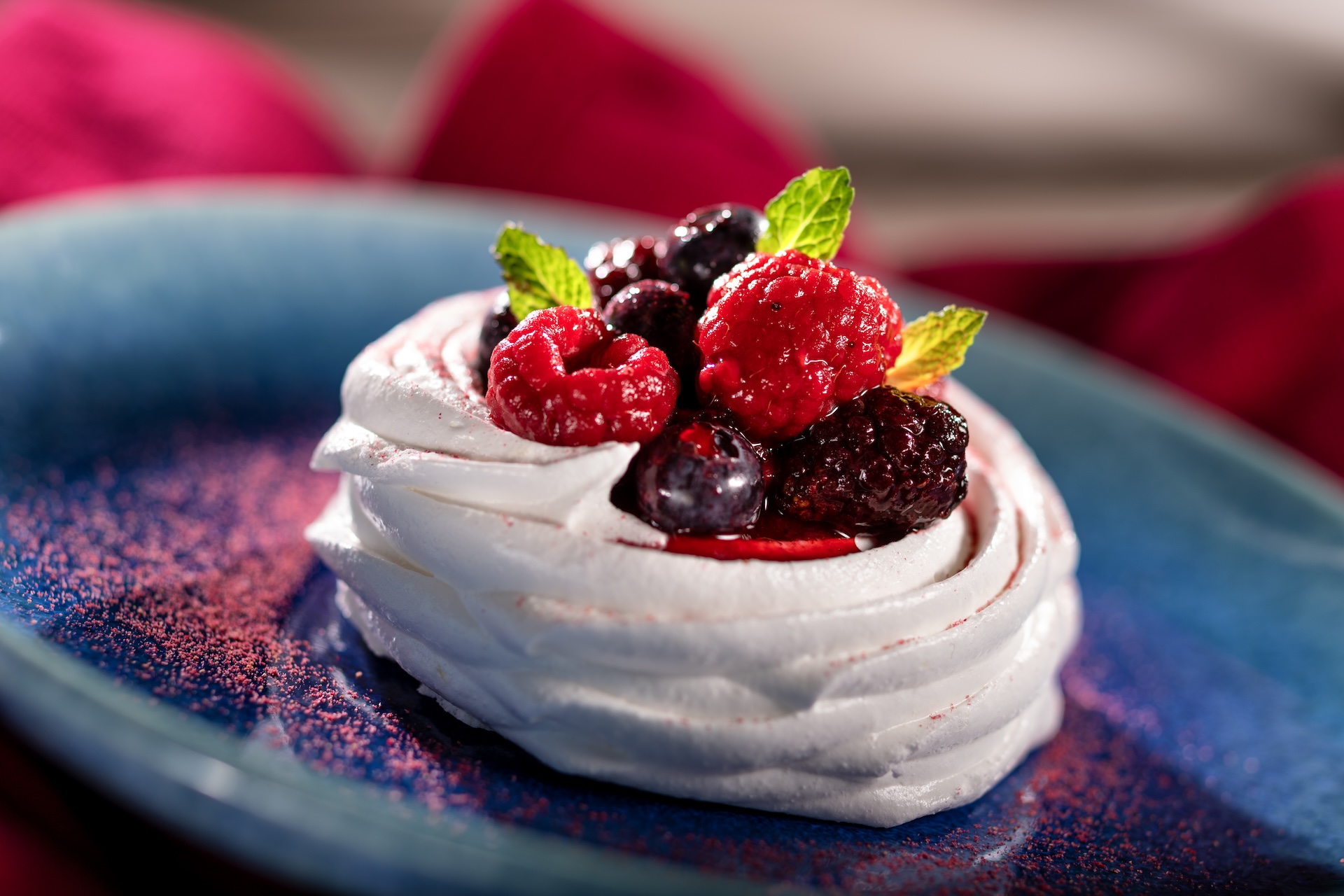 Mixed Berry Pavlova with crunchy meringue shell, macerated berries, and whipped cream  