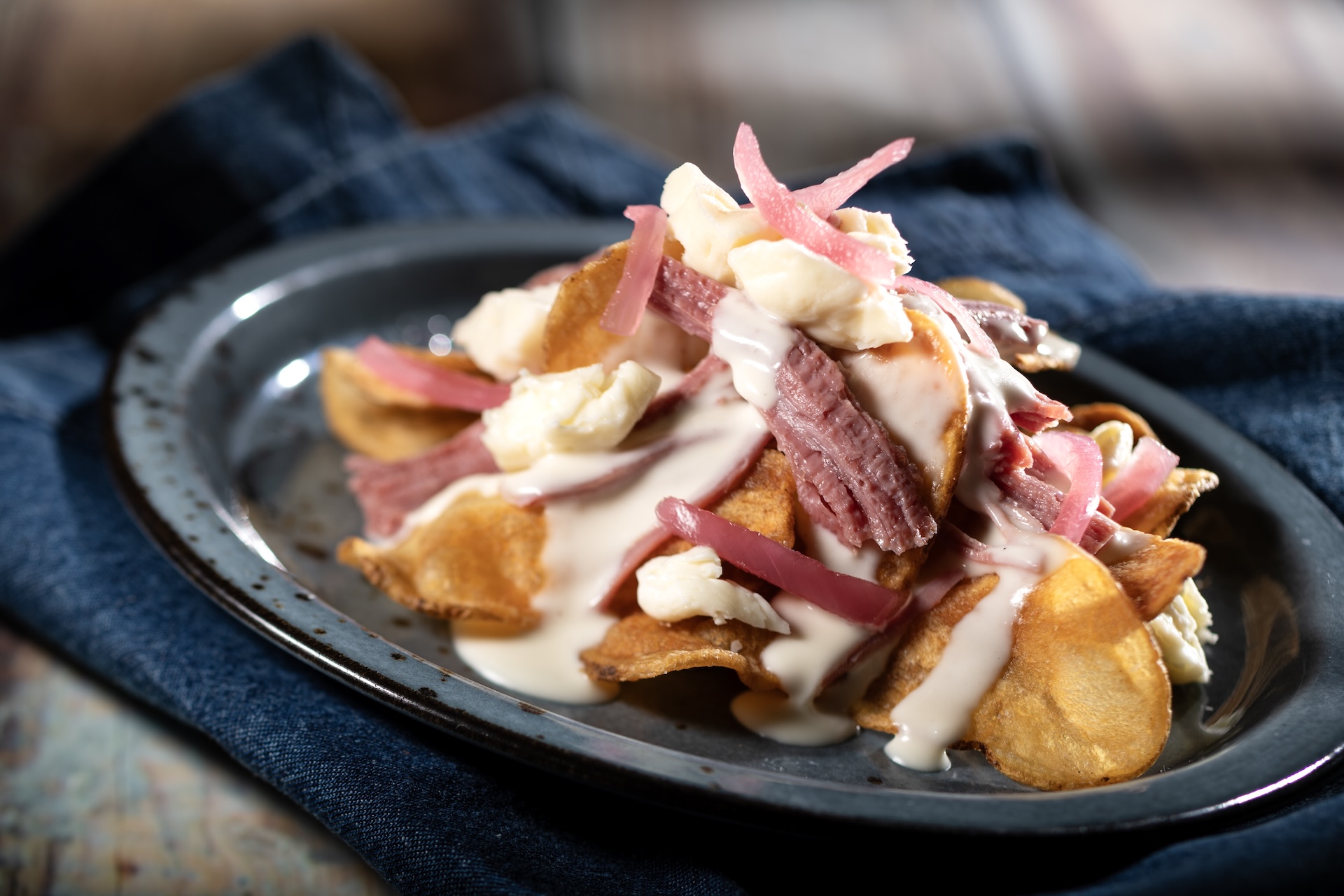Smoked Corned Beef with house-made potato chips, cheese curds, pickled onions, and beer cheese fondue  