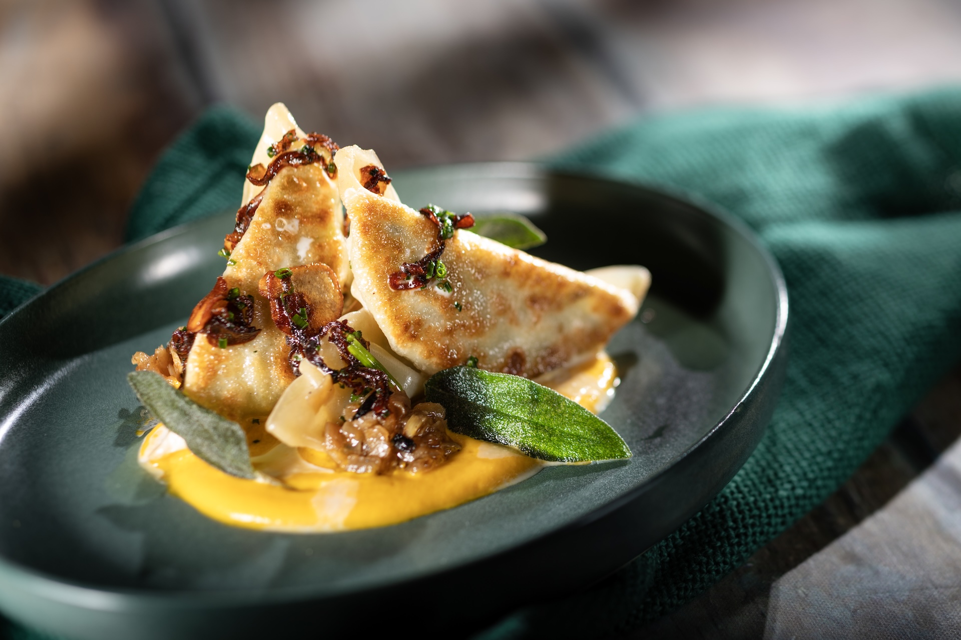 Edamame Dumplings: Butternut squash pur&eacute;e, caramelized onions, sage, and walnut-toasted garlic aillade 