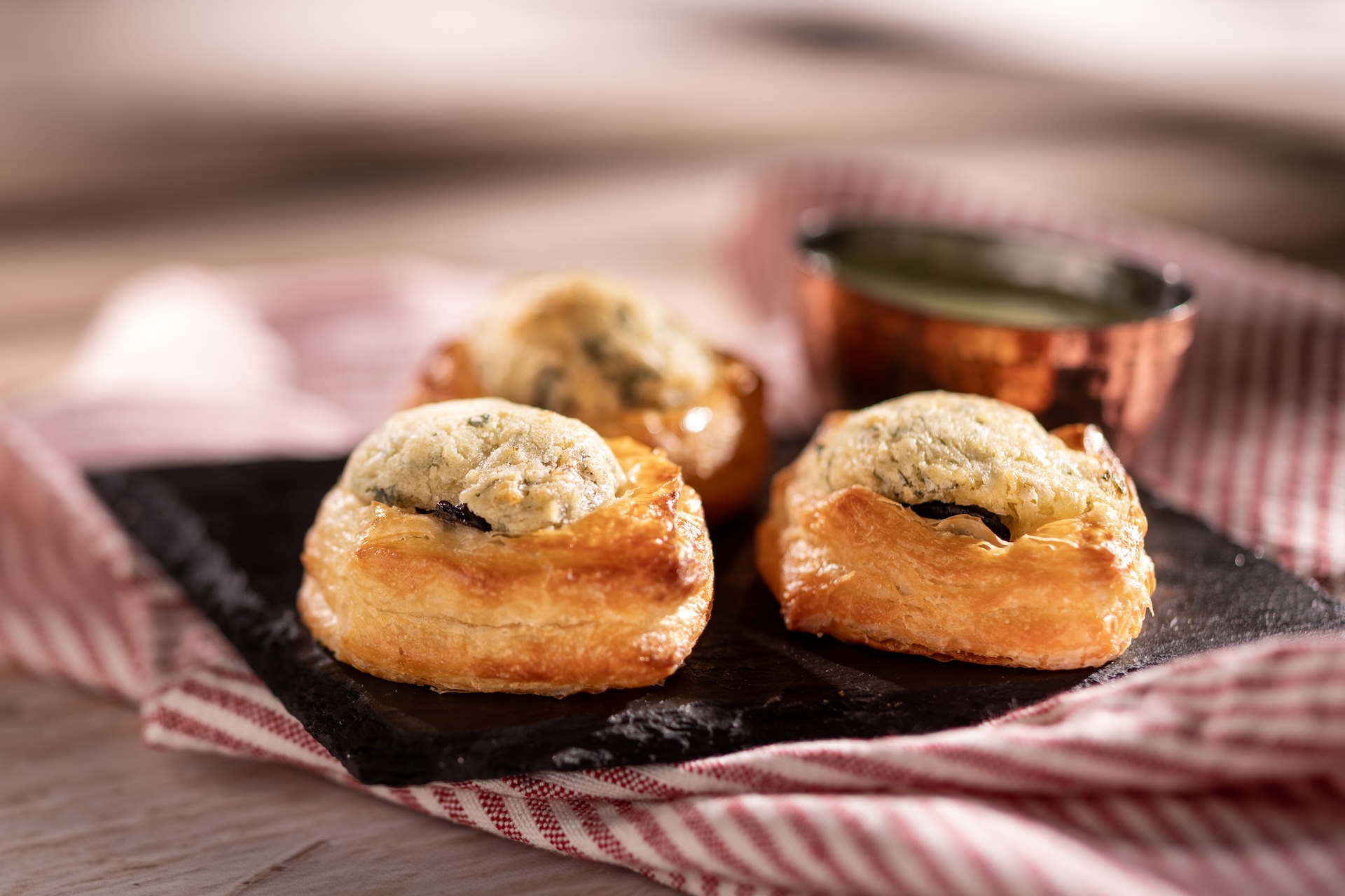 Trio d&rsquo;Escargots, Garniture a l&rsquo;ail et au Persil: Trio of escargot bites in croissant dough served with a garlic-parsley dip (Introduced in 1996)  