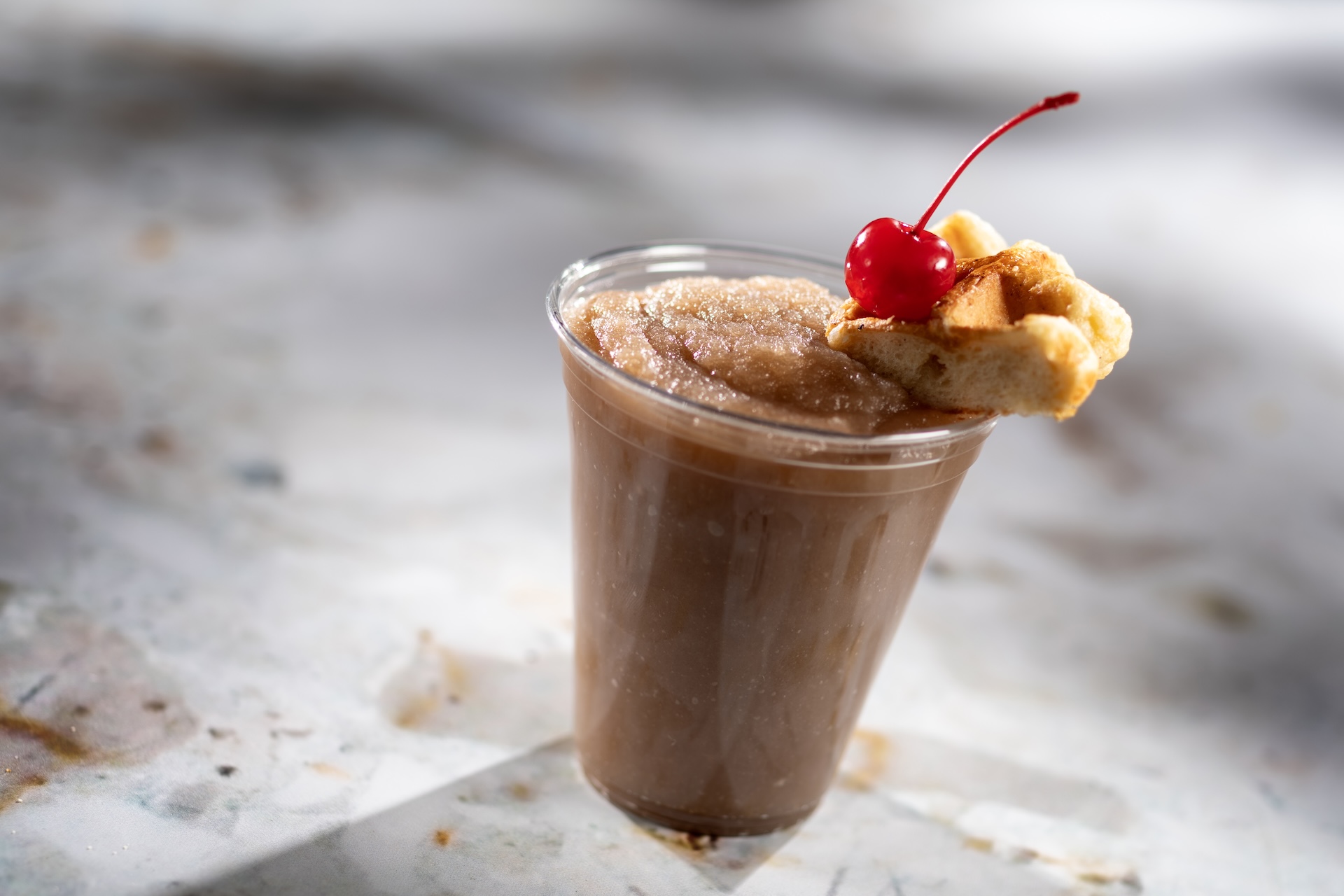 Frozen Waffle Old Fashioned: A frozen blend of Maker&rsquo;s Mark Kentucky Straight Bourbon Whisky, maple syrup, butterscotch syrup, and angostura bitters topped with a liege waffle and cherry (New) 