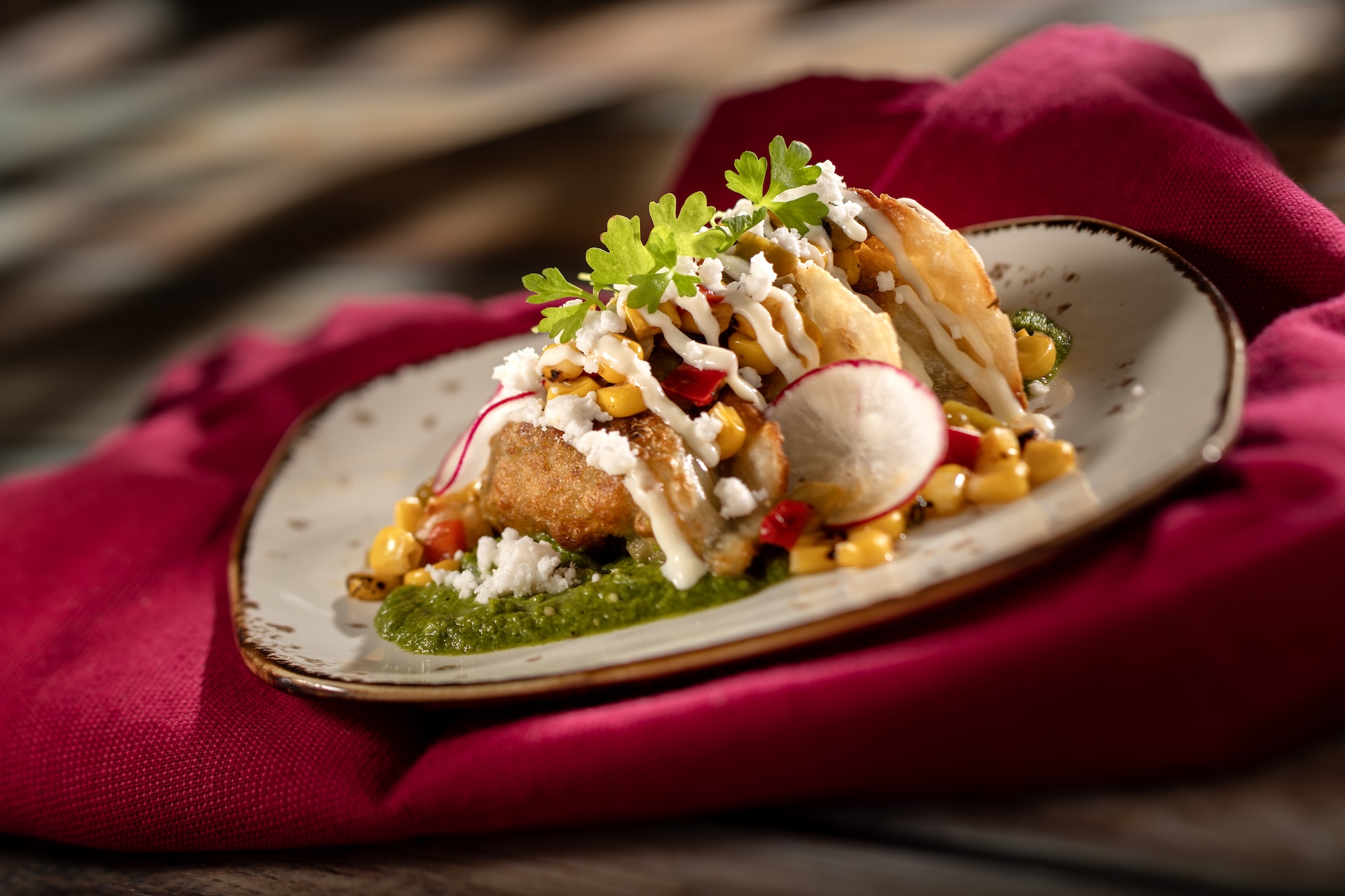 Street Corn-style Dumplings: Chicken dumplings with tomatillo salsa verde, street corn salad, cotija, lime crema, and cilantro 