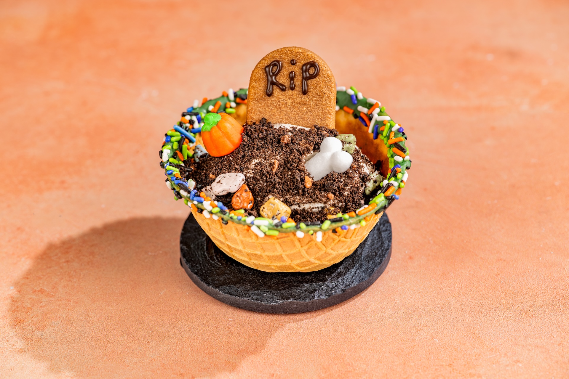 Boneyard Cookies and Scream Sundae: Cookies &lsquo;n cream ice cream, chocolate popping crumbs, chocolate cookie, sugar bone, pumpkin candy, and Halloween sprinkles served in a waffle bowl (New)