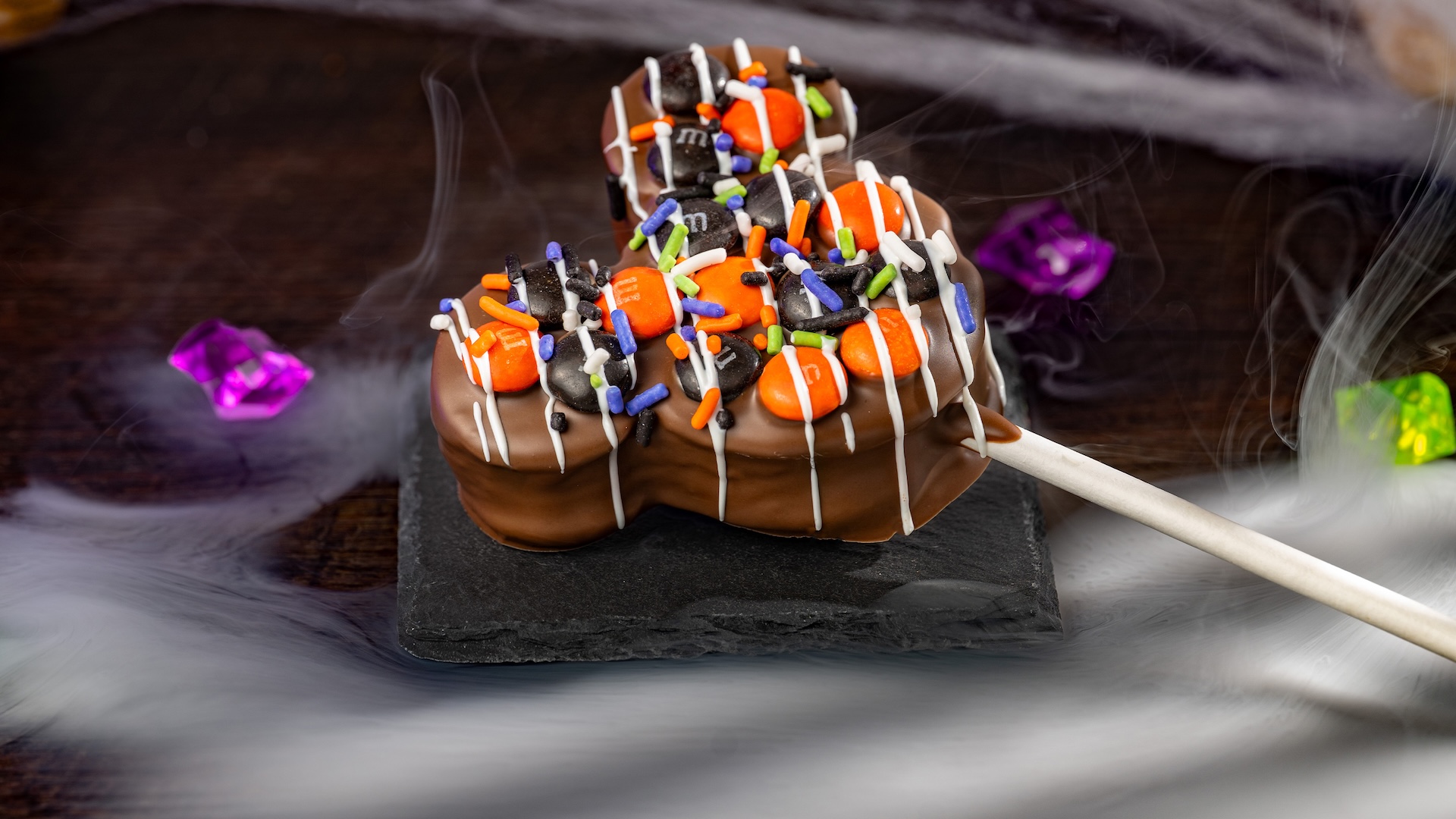 Mickey Halloween Marshmallow Pop with M&M&rsquo;S Milk Chocolate Candies: Marshmallow with milk chocolatey coating, M&M'S milk chocolate candies Halloween blend, Halloween sprinkles, and white chocolatey drizzle  