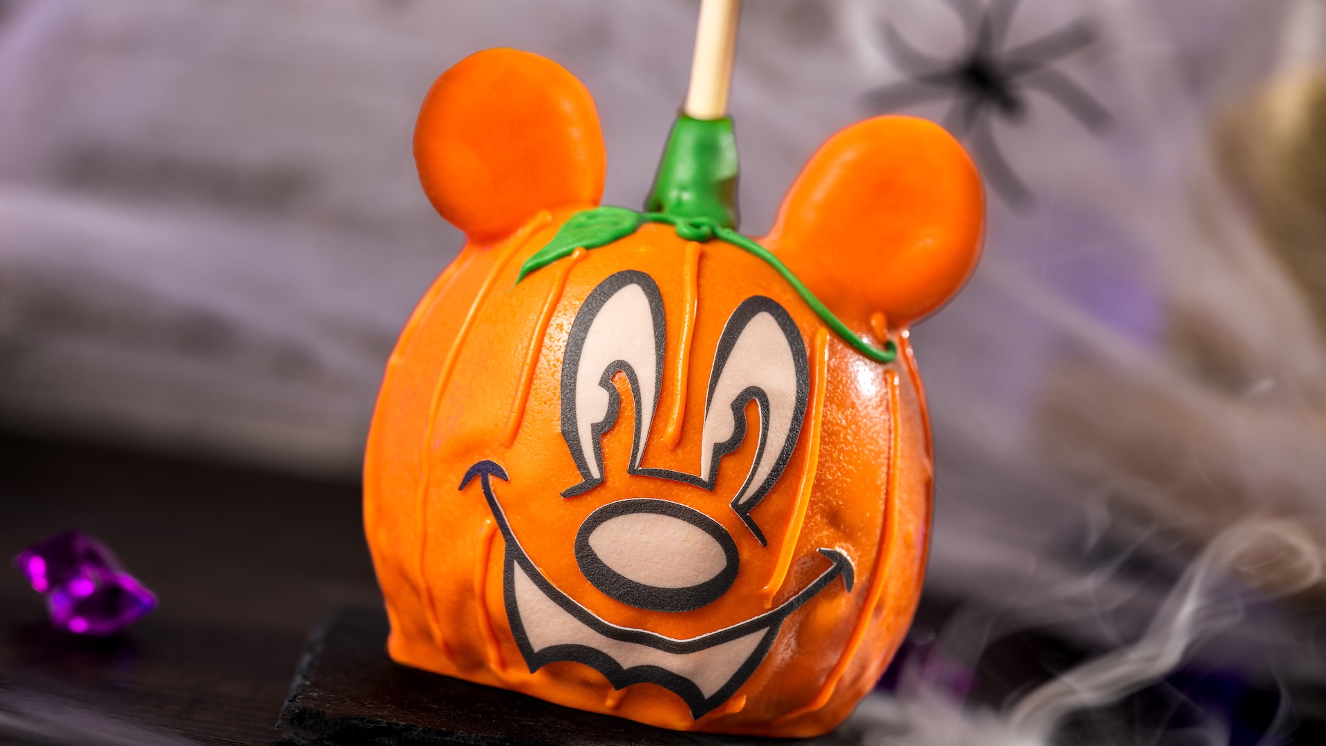 Mickey Pumpkin Caramel Apple: Granny Smith apple with marshmallow ears dipped in Werther&rsquo;s Original caramel and colored chocolatey coating with fondant features 