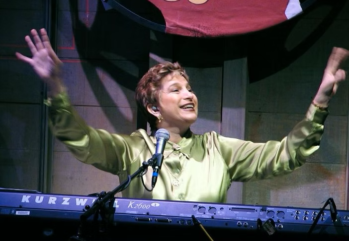 Carol smiling at the piano.