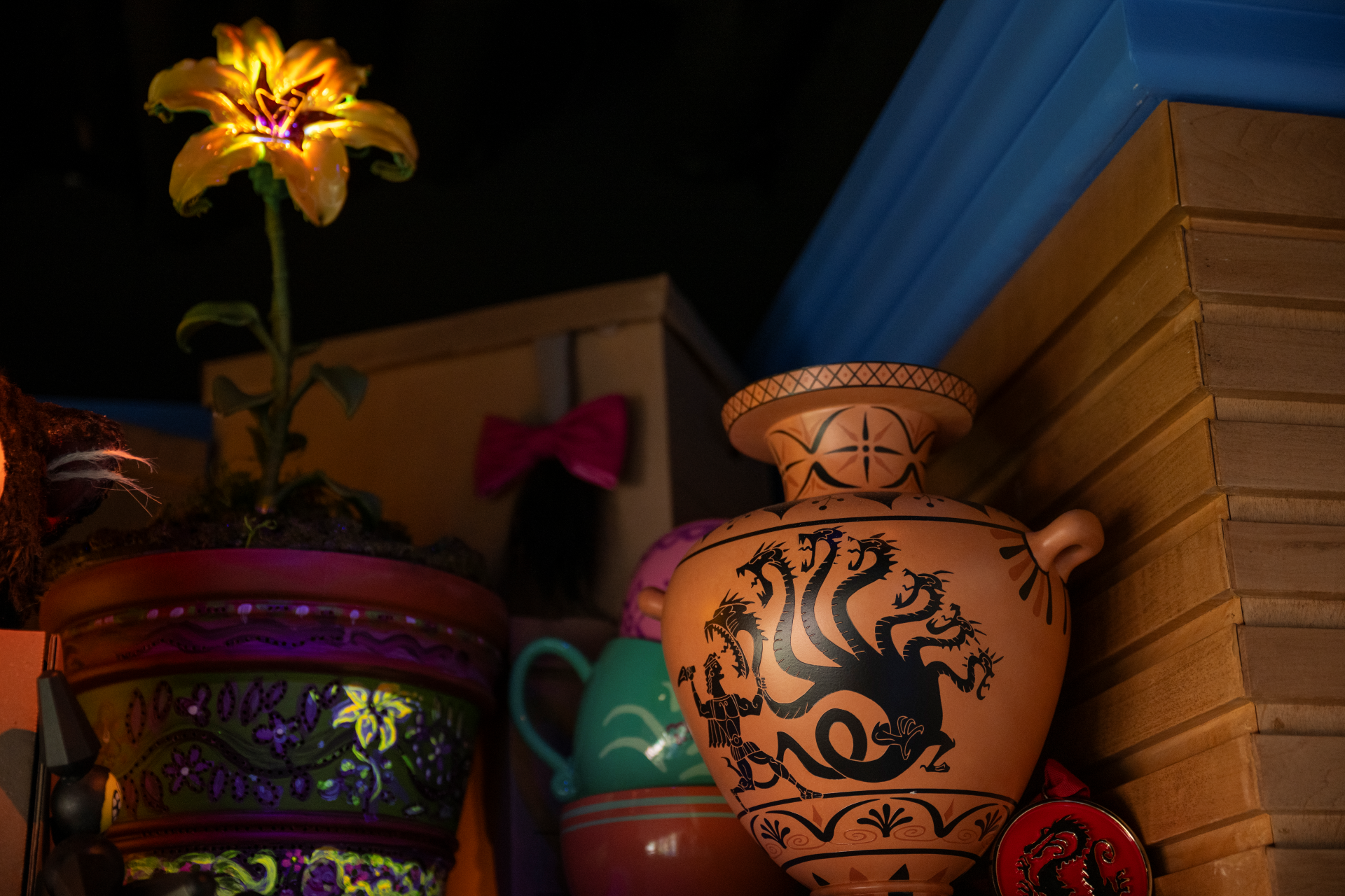 Decorative pottery with a mythological design and a glowing flower.