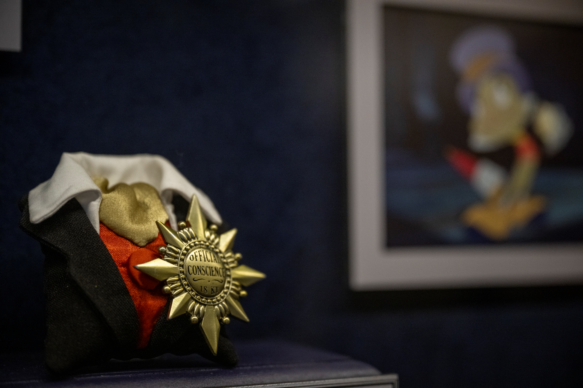 A small outfit with a badge labeled 'Official Conscience' on display.