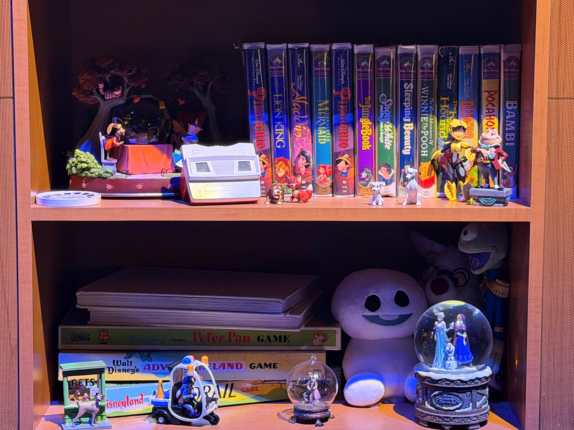 Shelves displaying Disney VHS tapes, figurines, and themed collectibles.