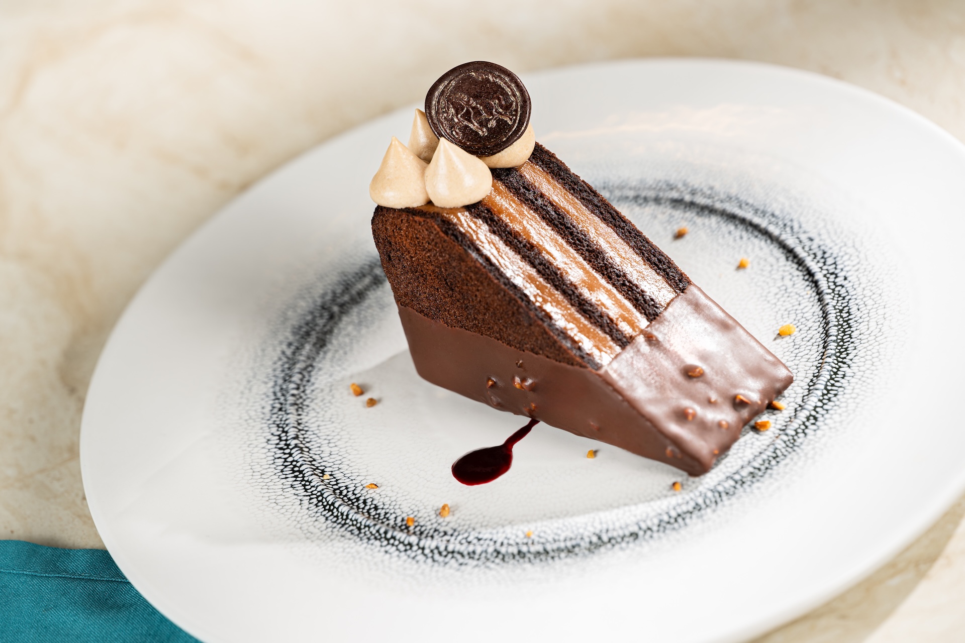 Chocolate hazelnut cake slice with decorative toppings on a plate.