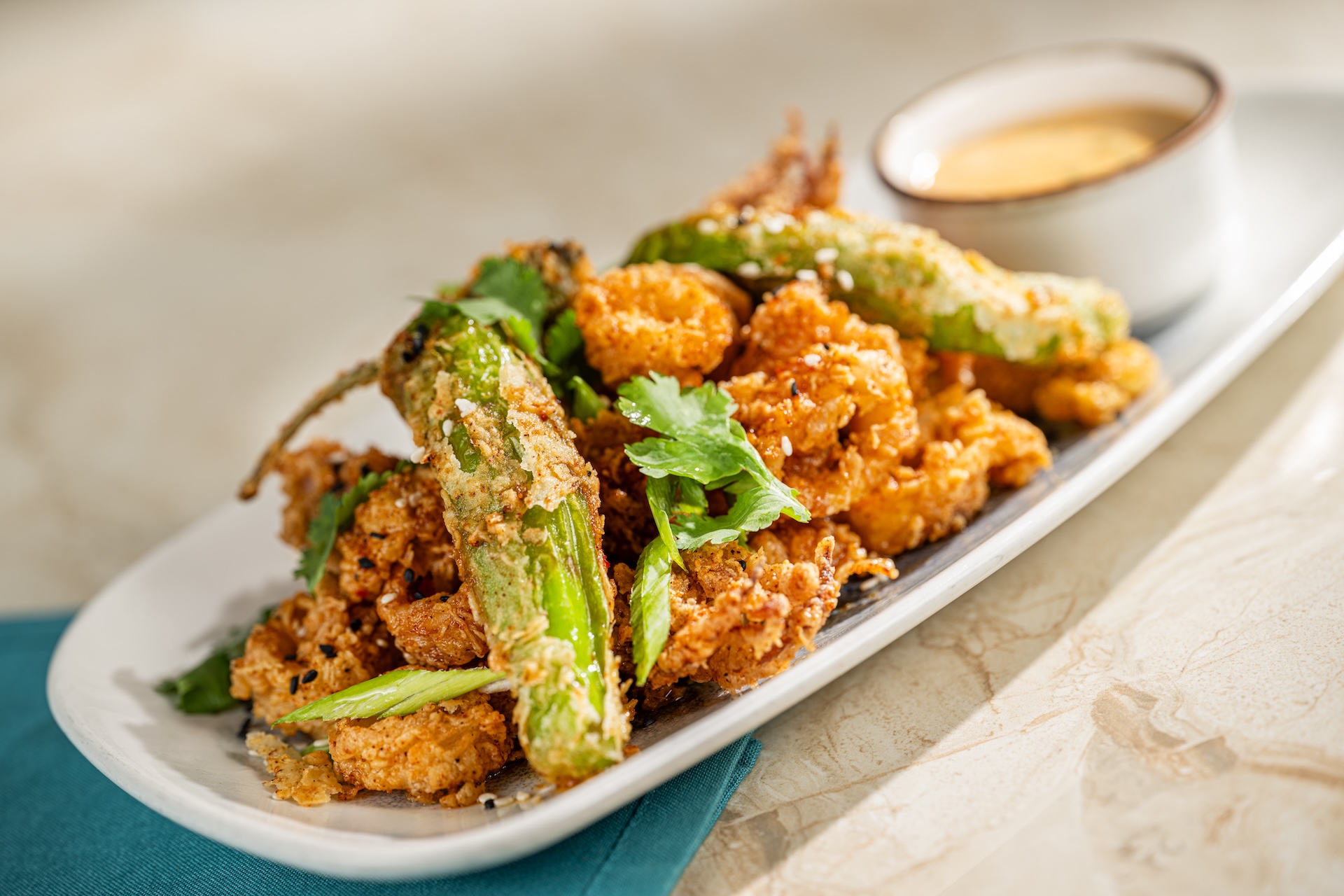 Fried calamari and peppers garnished with cilantro on a plate.