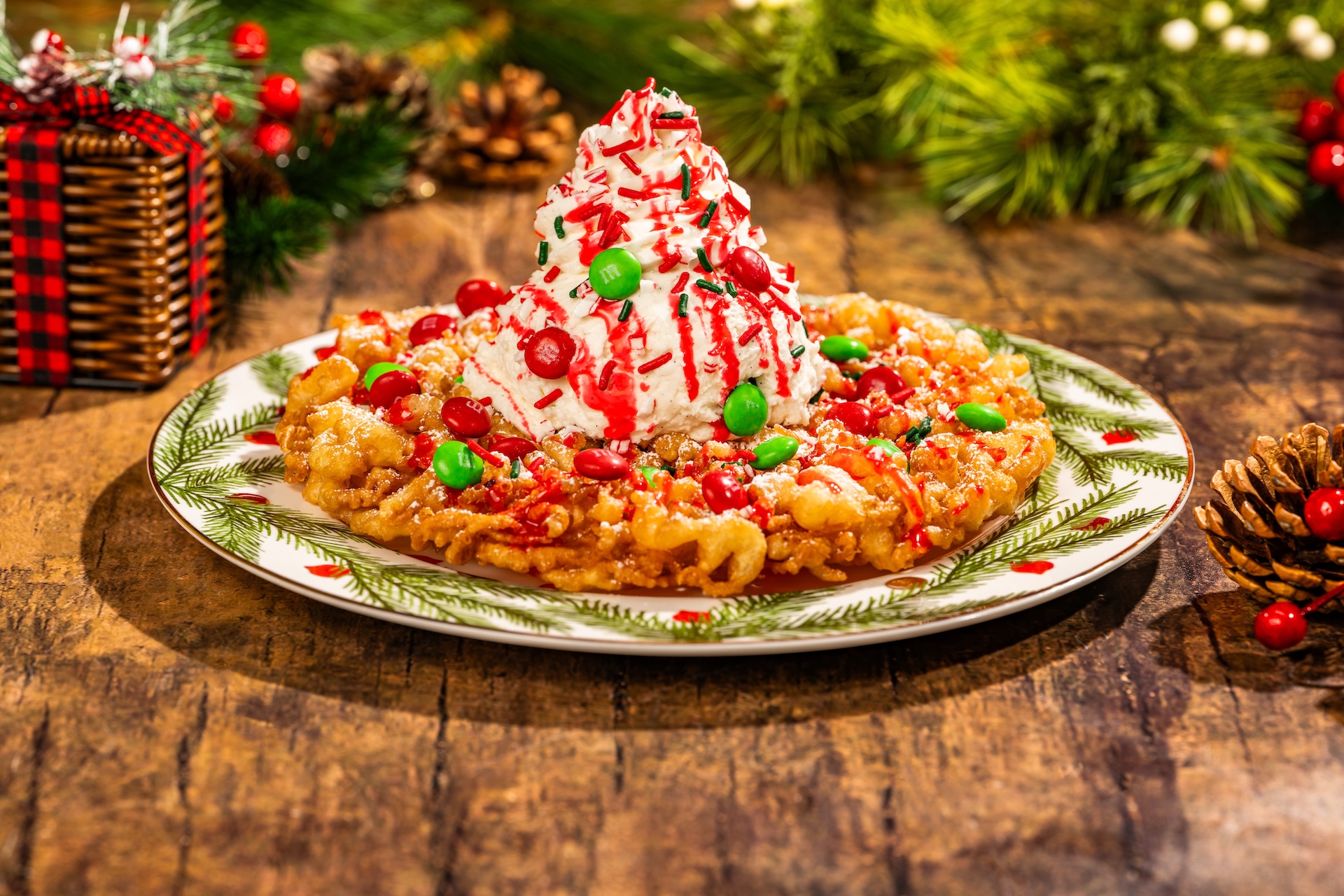 Peppermint Bark Funnel Cake topped with vanilla ice cream, peppermint and chocolate sauces, M&M'S Milk Chocolate Holiday Blend, whipped cream, crushed peppermint, and festive sprinkles (Available during Mickey&rsquo;s Very Merry Christmas Party only) 